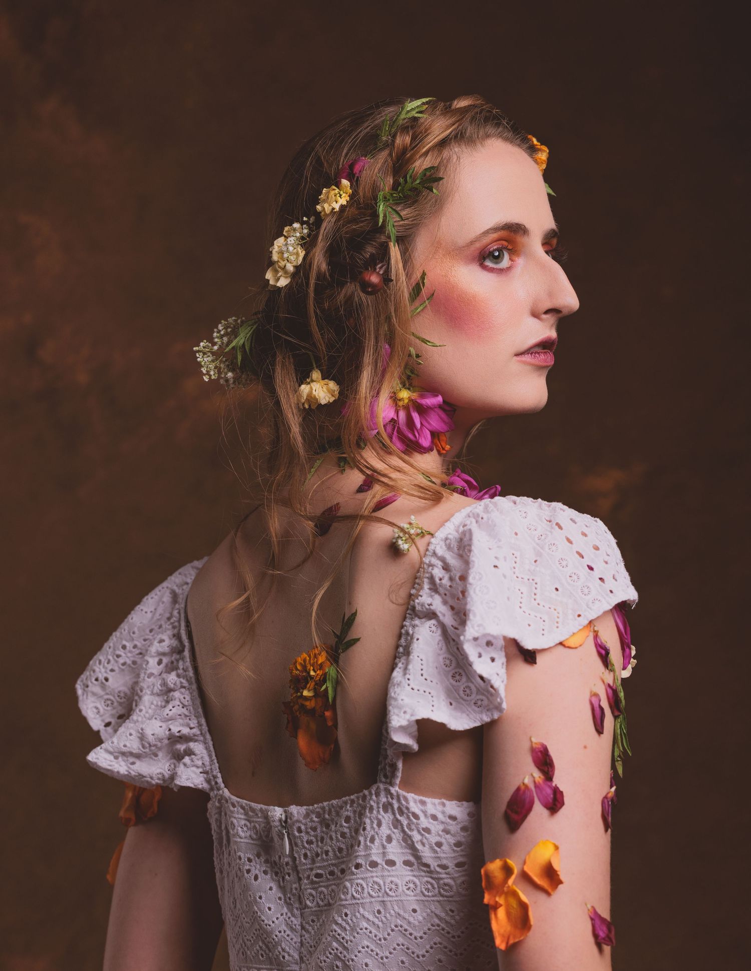 Ethereal portraits featuring white lace dress and floral accessories against dark background.