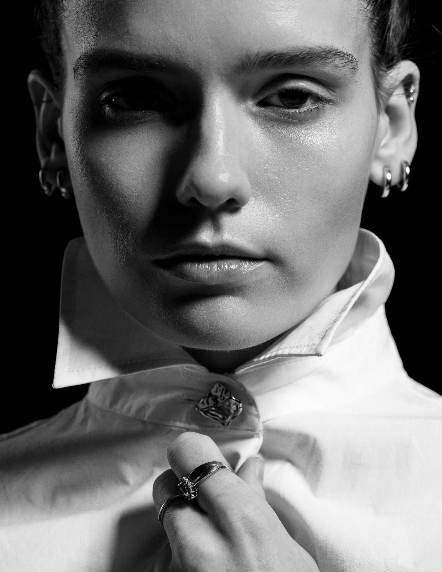 High contrast black and white close-up portraits with dramatic shadows and white collar.