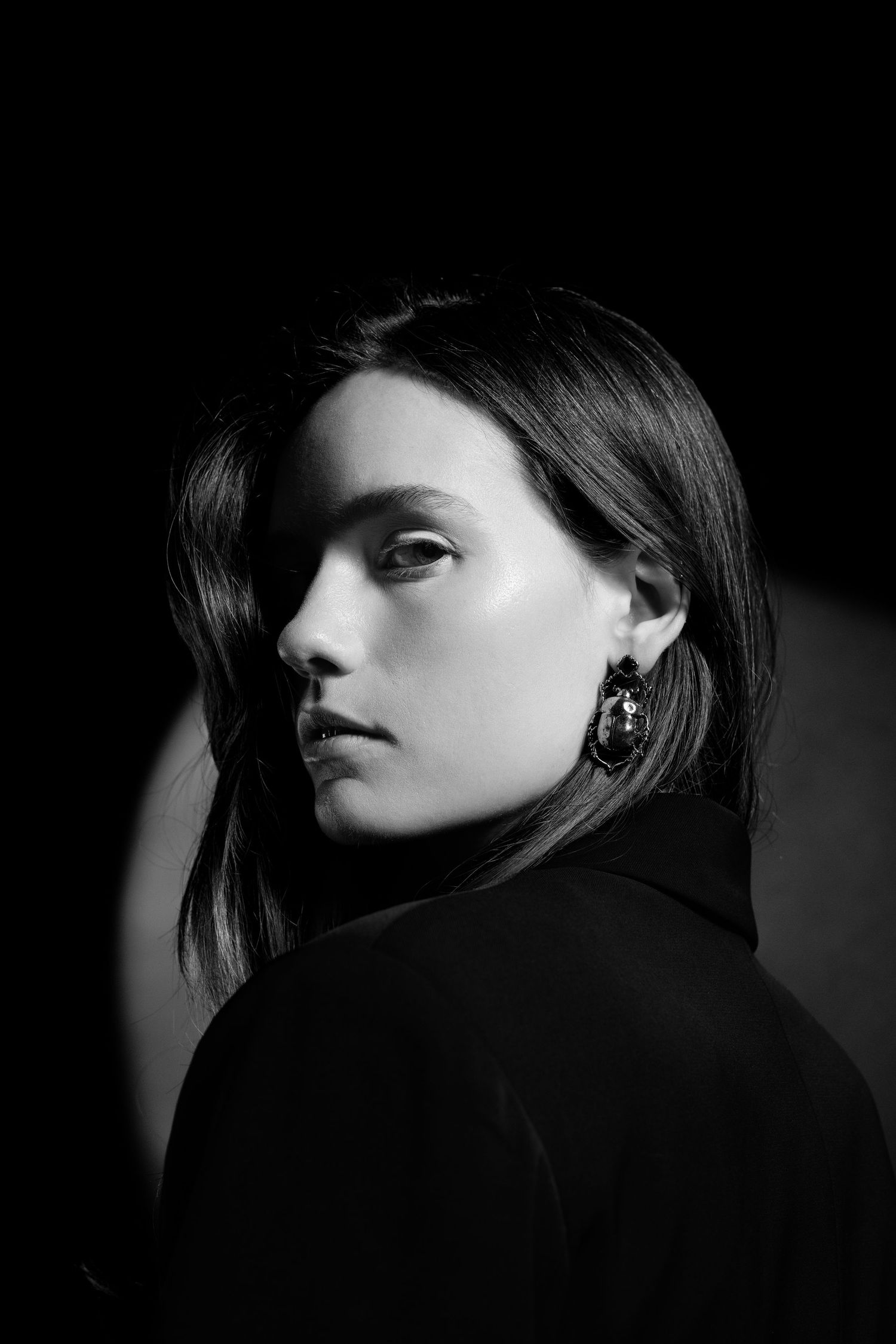 Dramatic black and white portrait showing dark silhouettes and shadows with moody lighting.