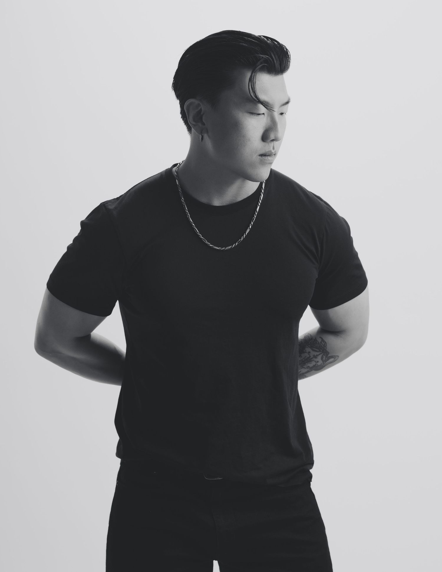 Black and white portrait series showing person in black t-shirt posing against white background in different stances.