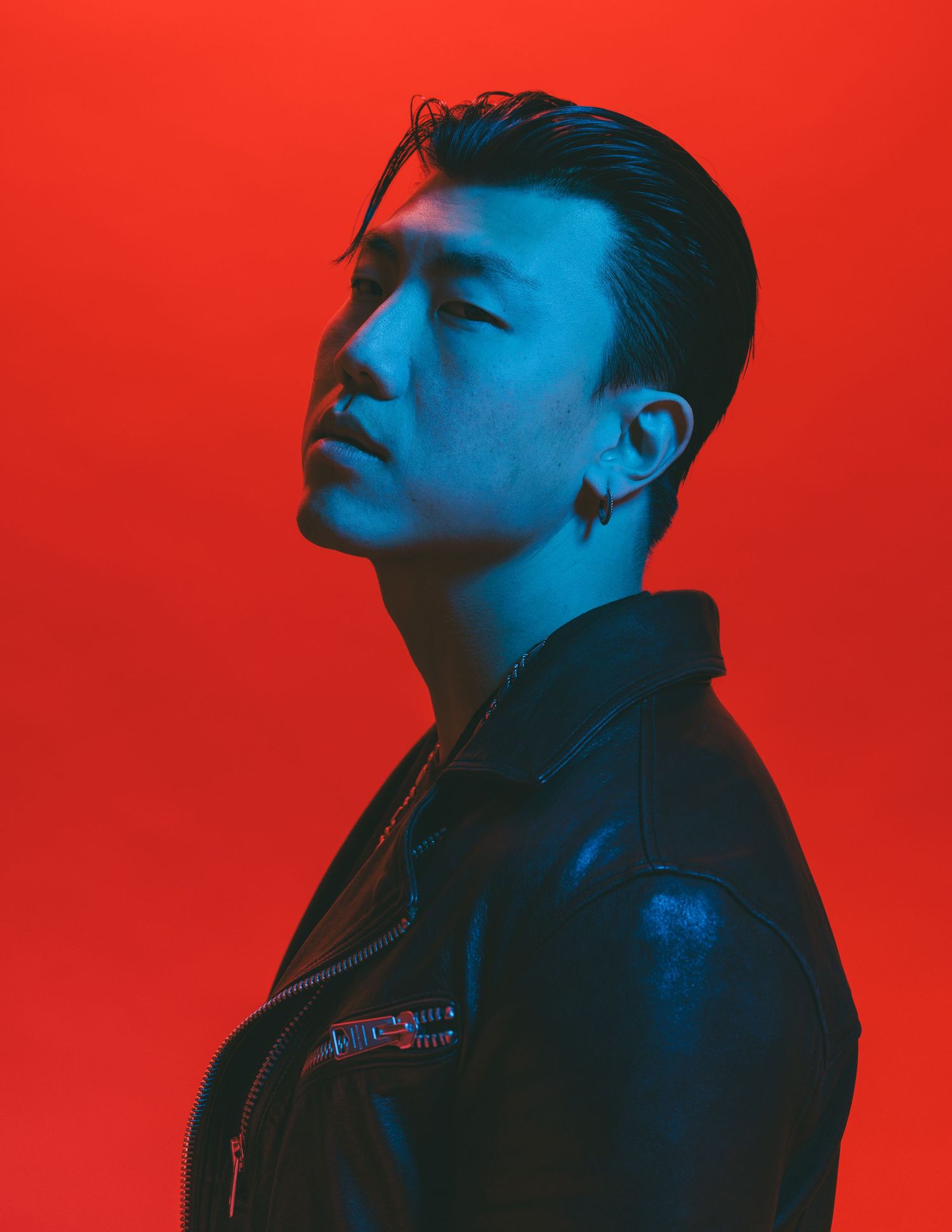Dramatic profile portraits with blue lighting against vibrant red background.