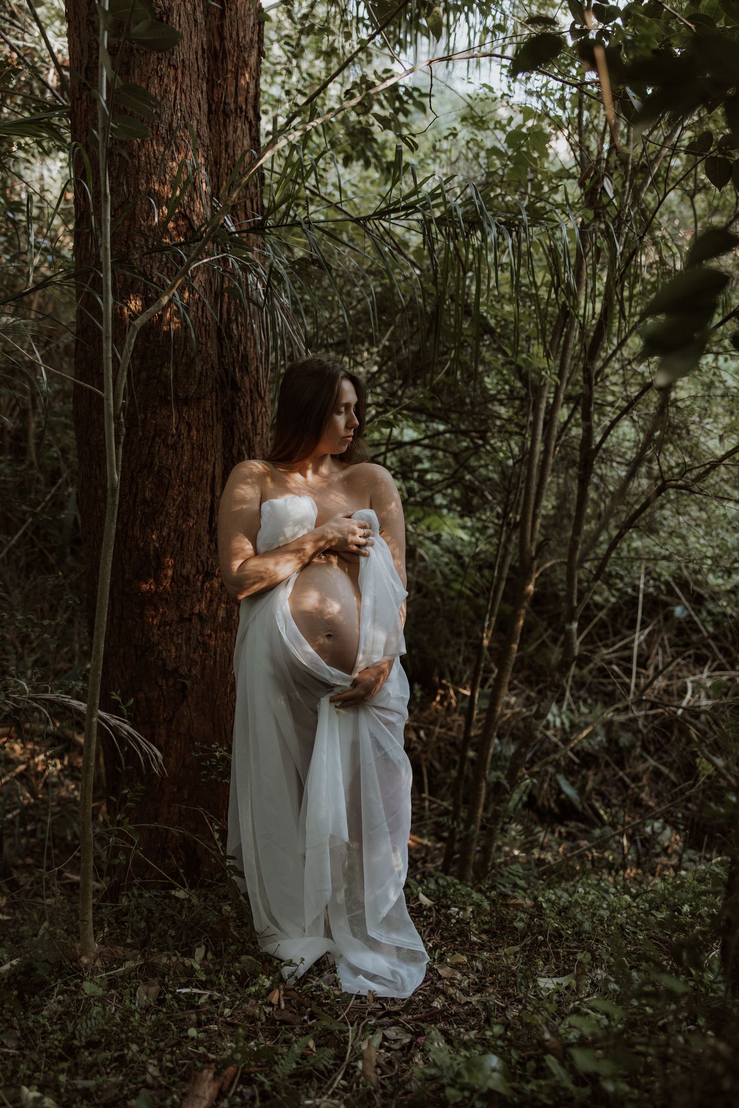Maternity mother standing in the forest, breathing in the fresh air looking the picture of health and happiness.