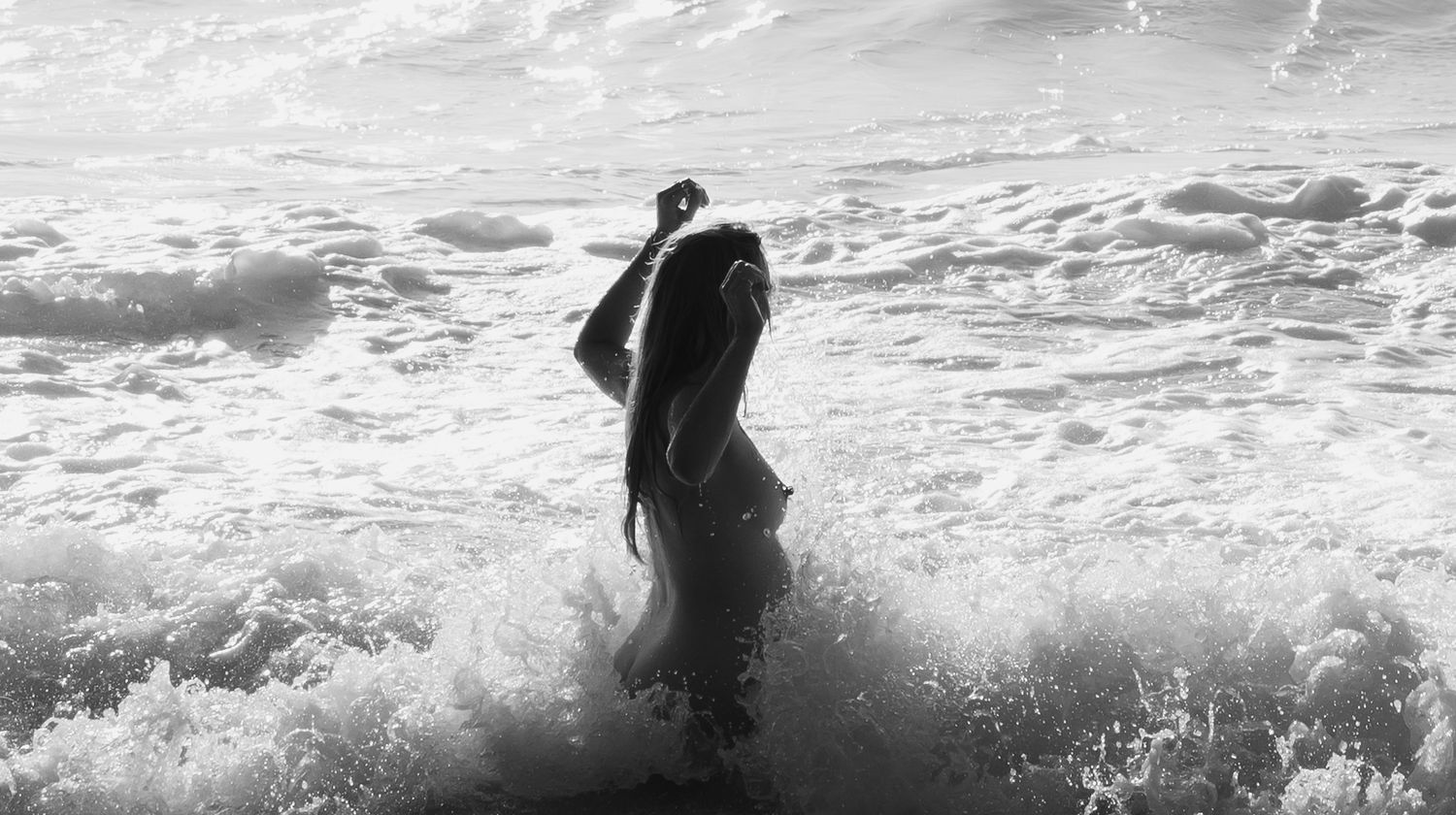 Pregnant mum takes a morning ocean swim with waves crashing around her.
