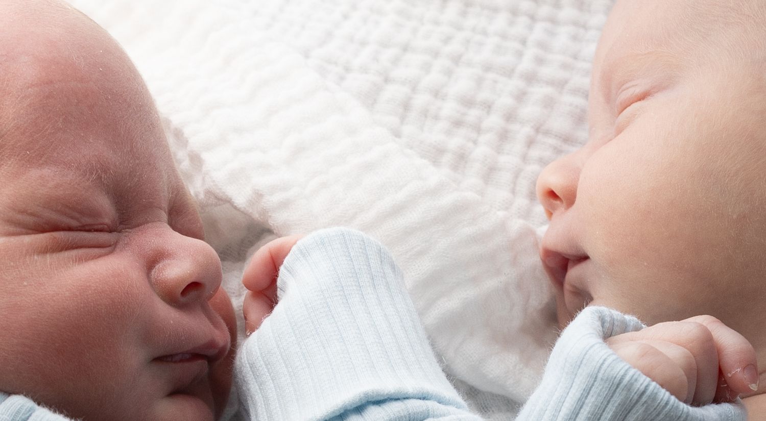 Twins settling each other to sleep, holding hands. Taken in home in Newcastle against a window filled with morning light.