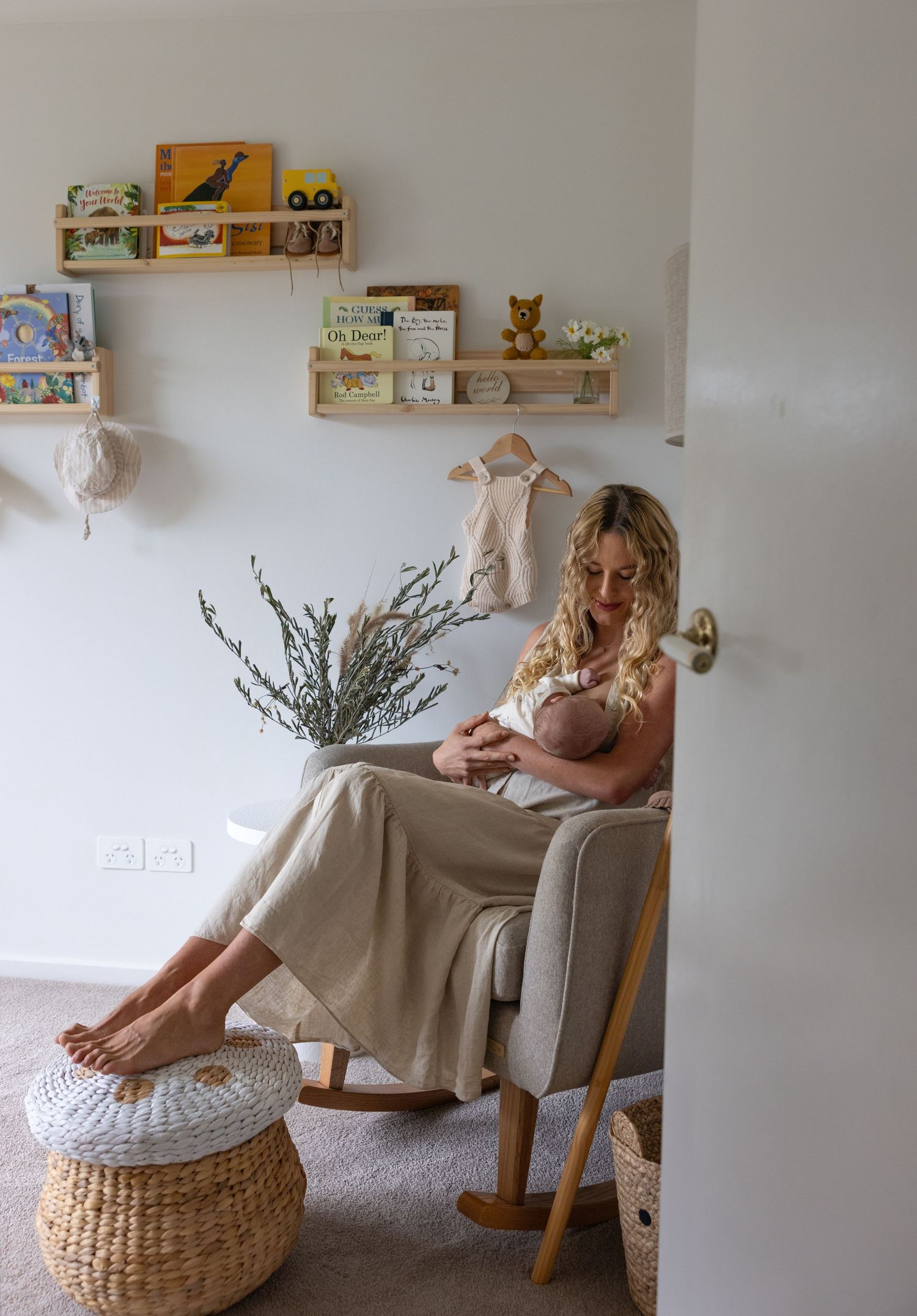Mother nursing her newborn son in a cosy nursery at home in Newcastle.