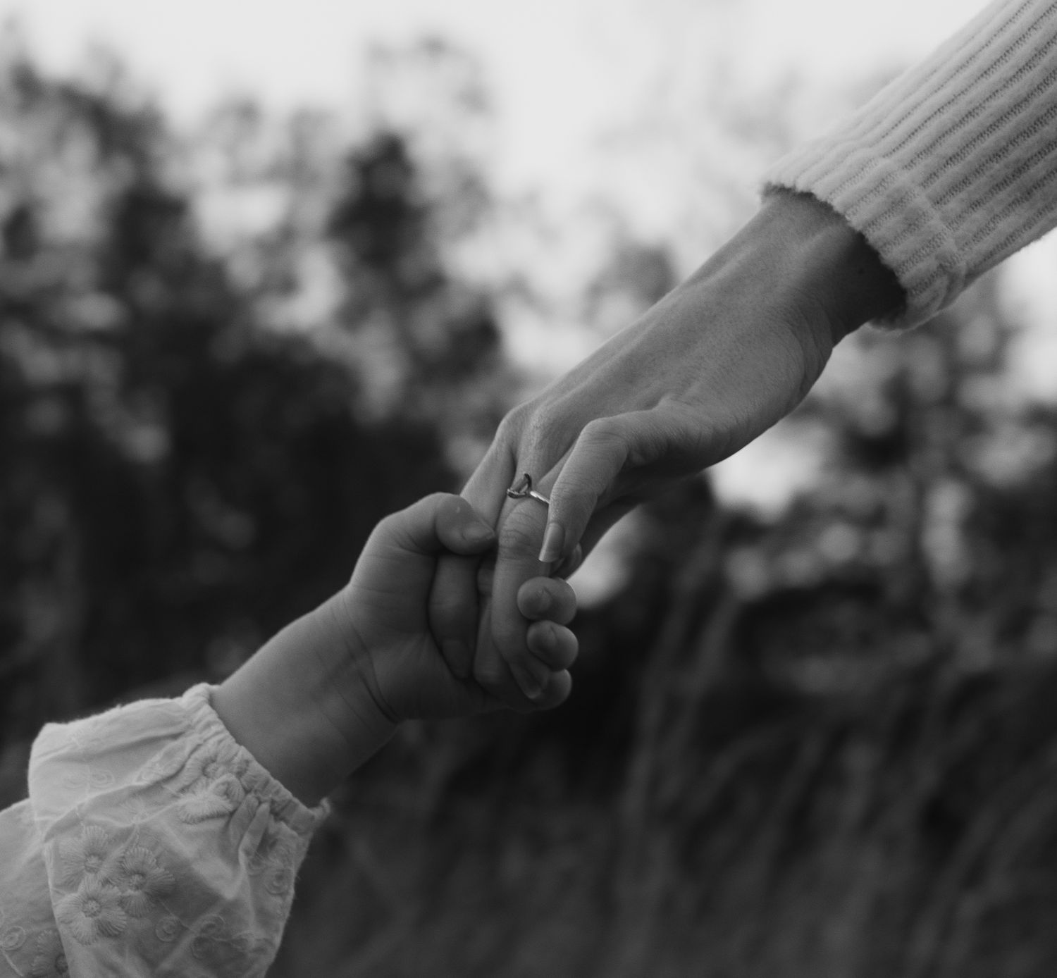 Close up of a mother holding her daughter's hand, engagement ring shining in the soft afternoon sunlight in Lake Macquarie.