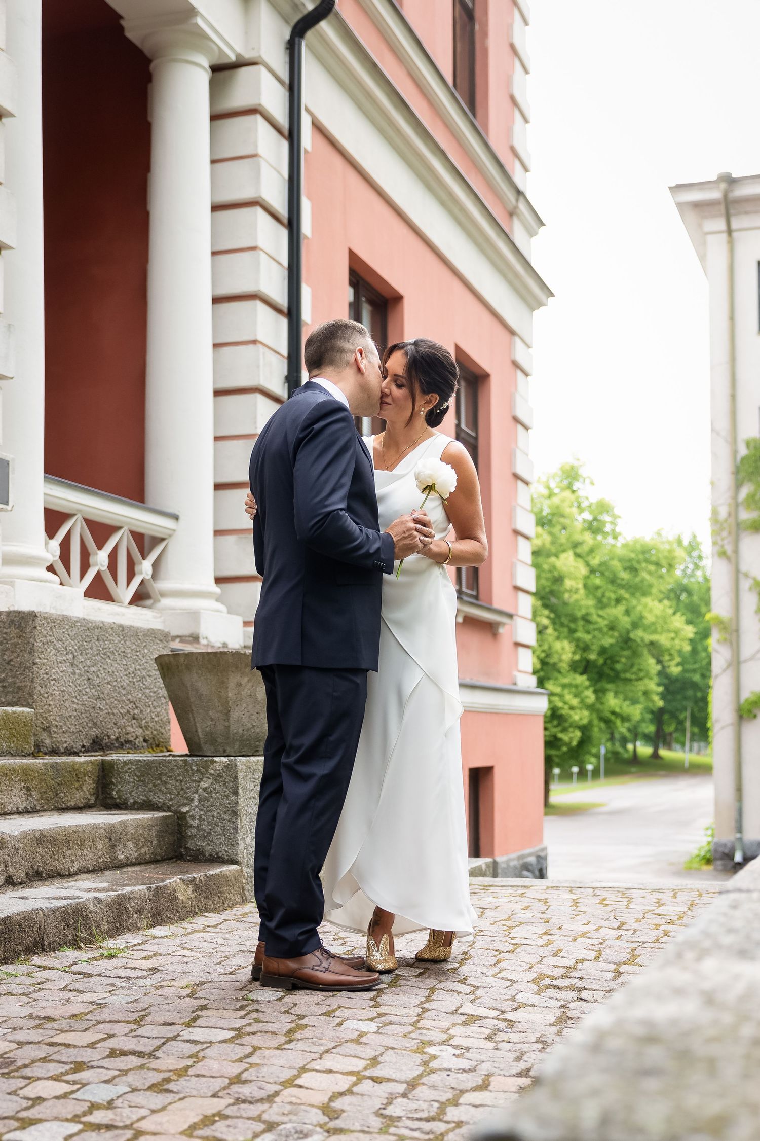 Hääpotretti rakennuksen edessä
