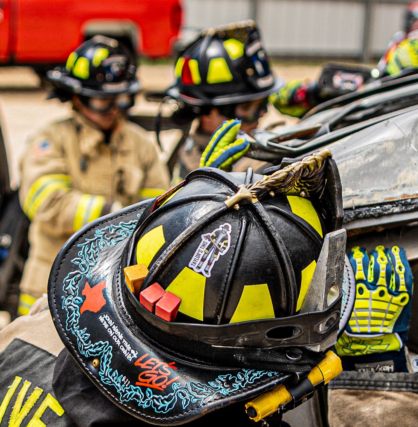 Collection of decorated firefighter helmets with reflective stripes and safety gear.