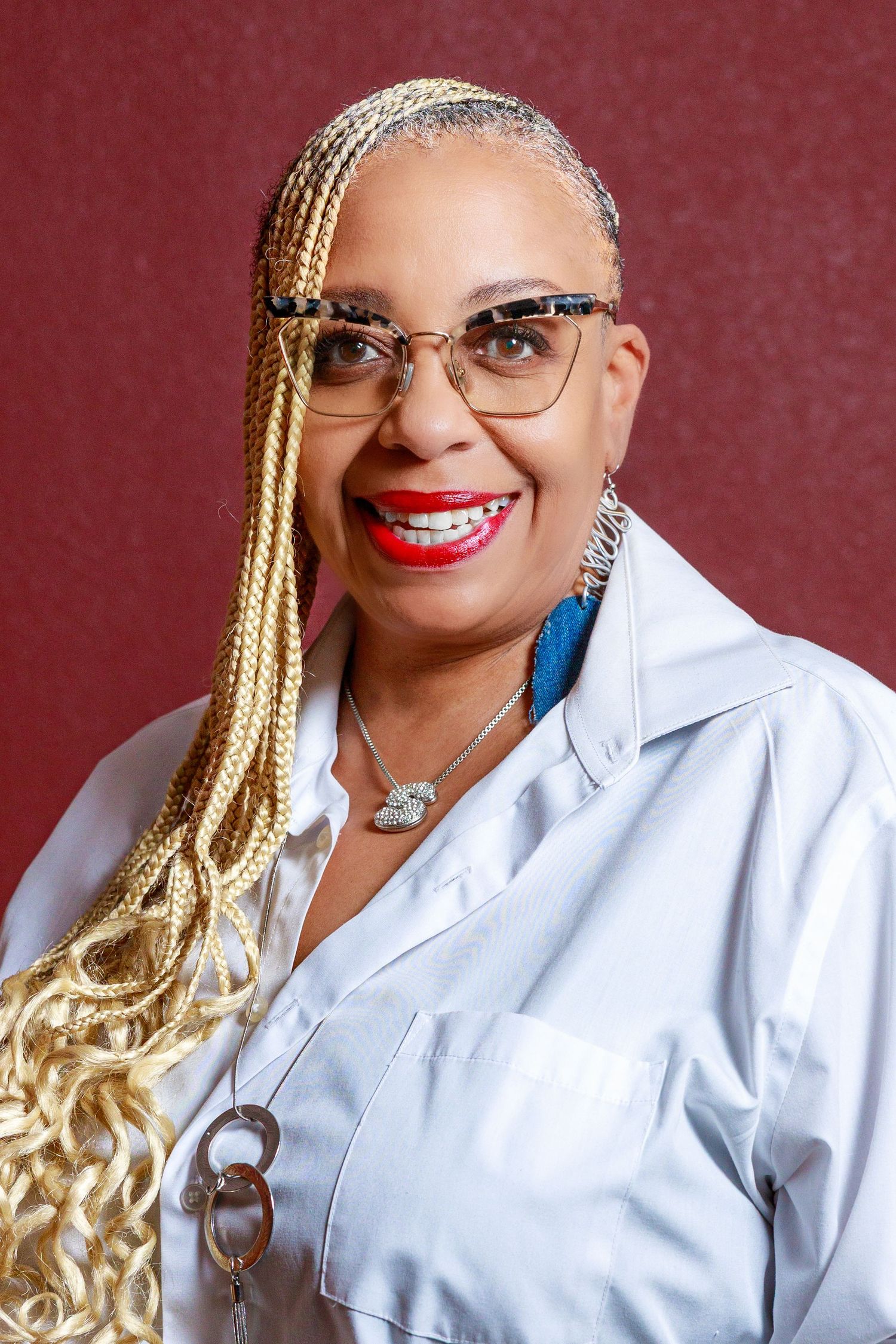 Professional portrait series showing blonde braided hairstyle and white button-up shirt against burgundy background.
