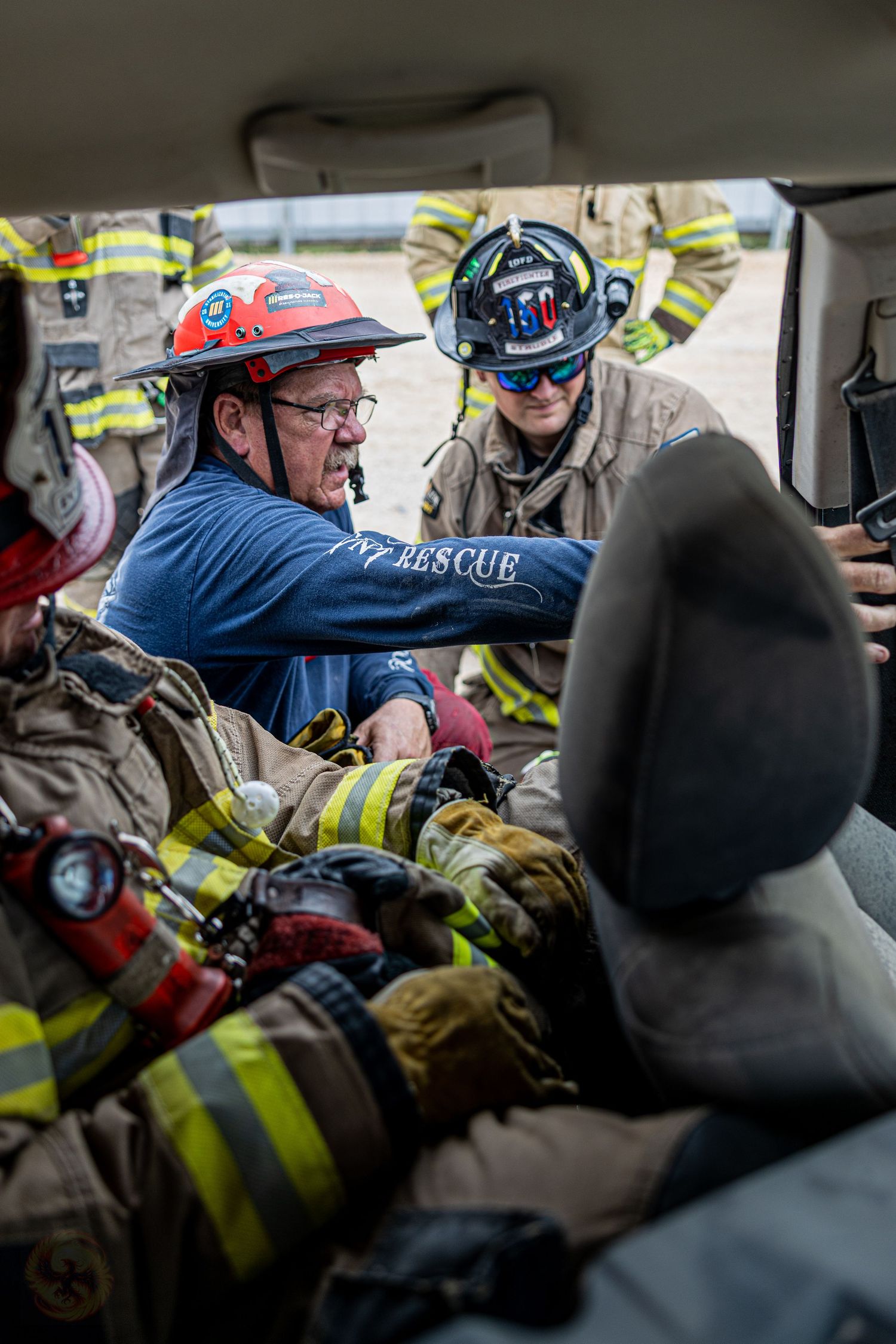 Firefighters in protective gear work together inside what appears to be a training exercise scenario.