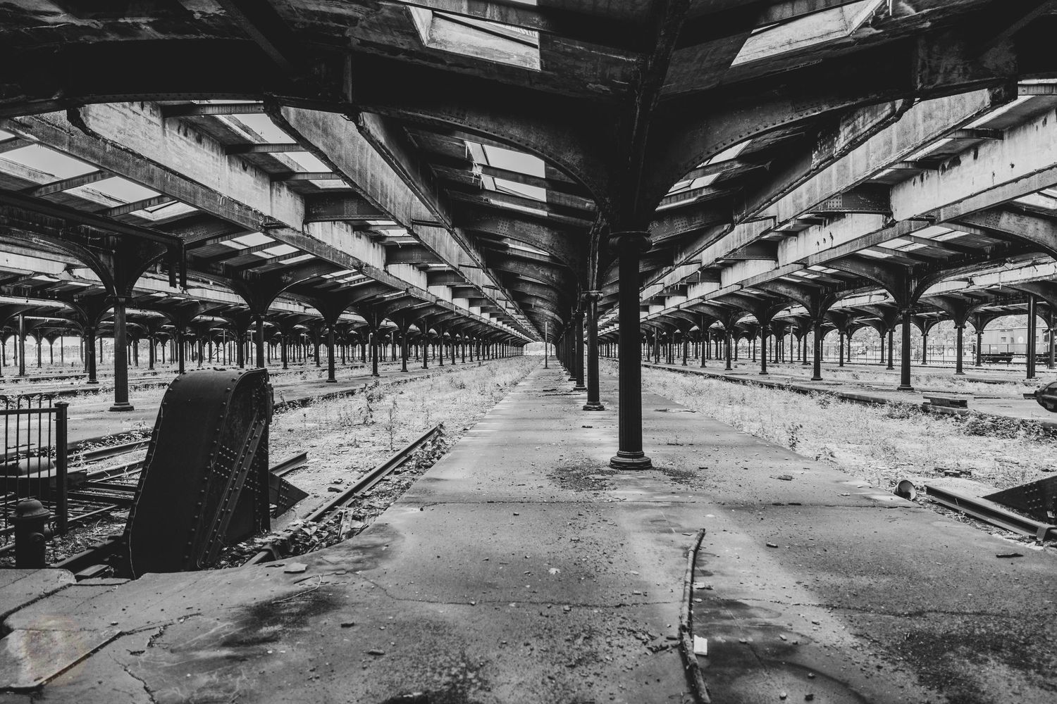 Black and white panoramic view of an empty industrial warehouse interior.
