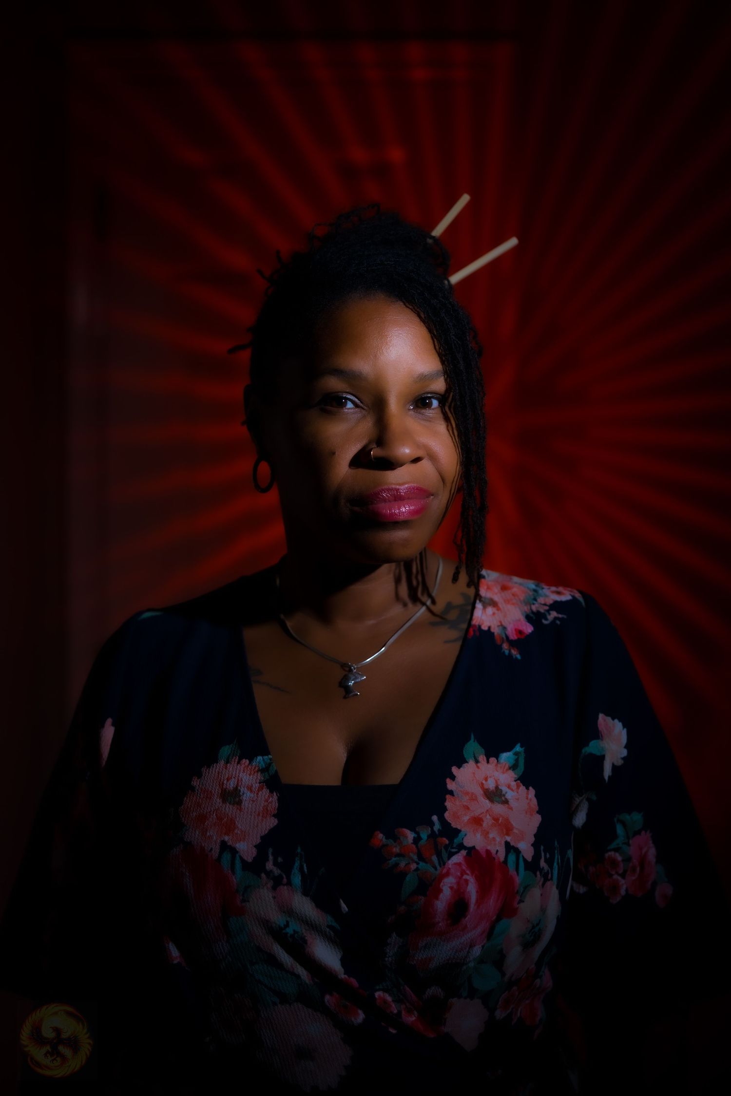 Studio portrait series with dramatic red lighting and floral accents.