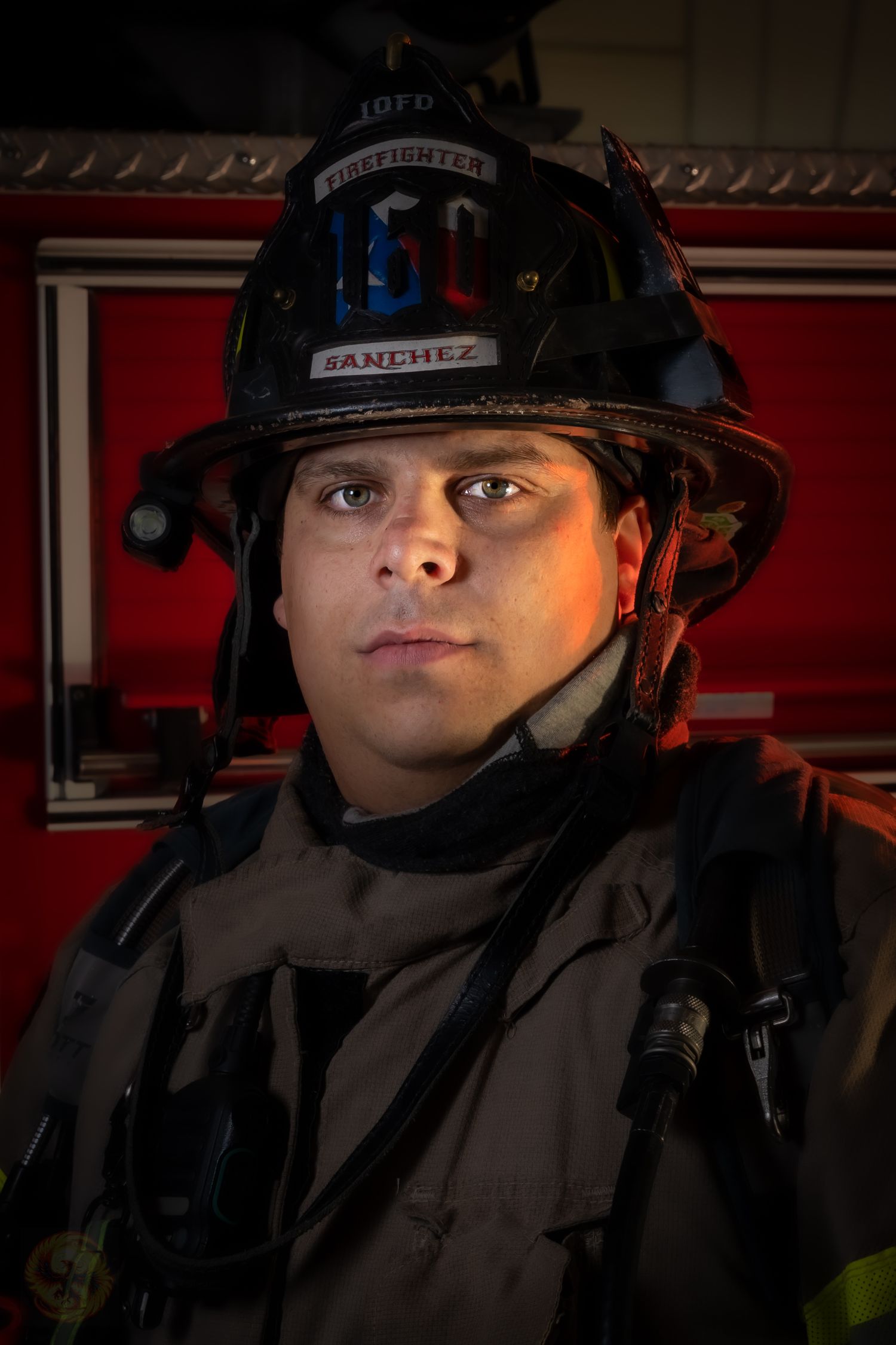 Dramatic portrait of firefighter in full protective gear and helmet.