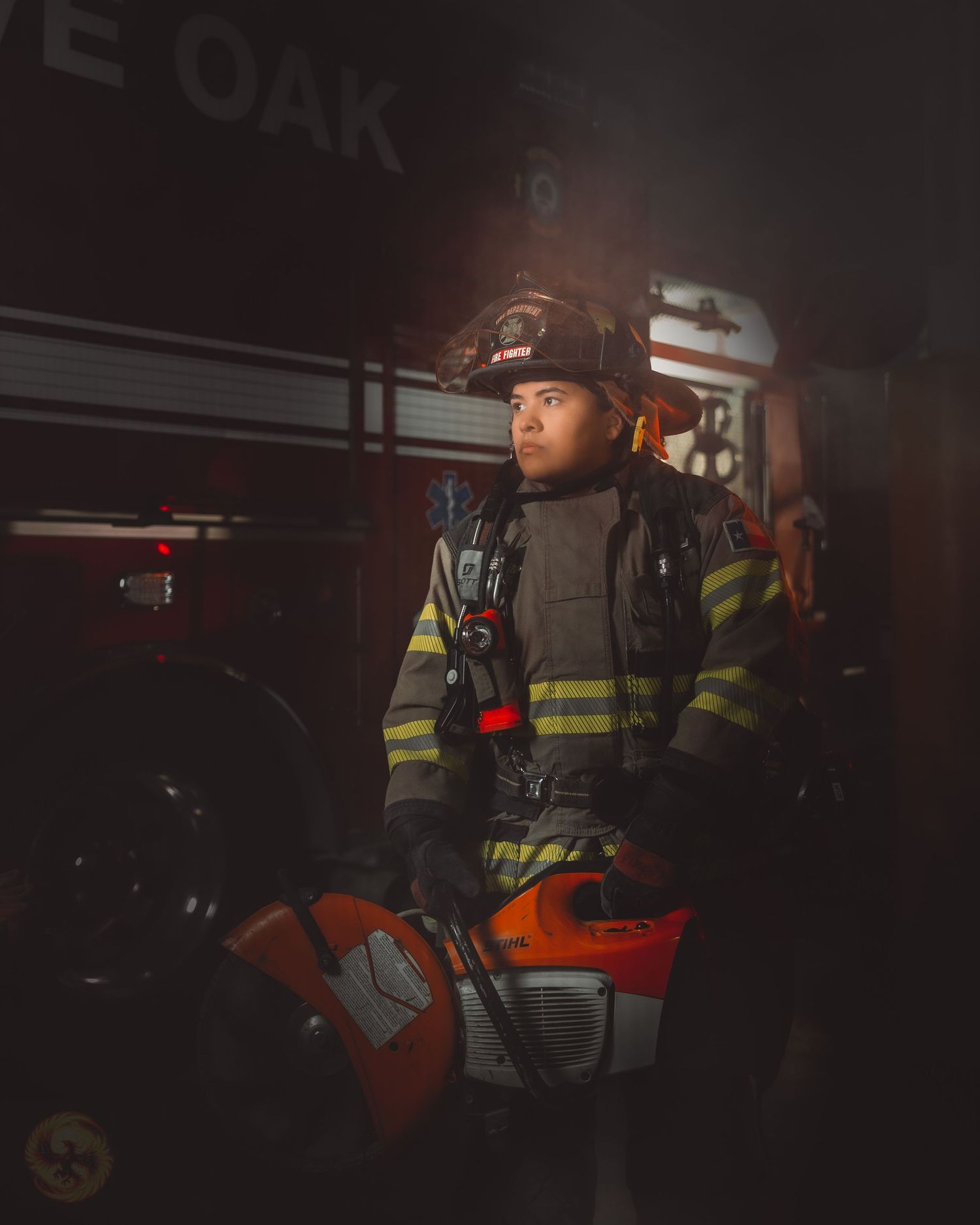 Firefighter in full protective gear illuminated by dramatic lighting at night.
