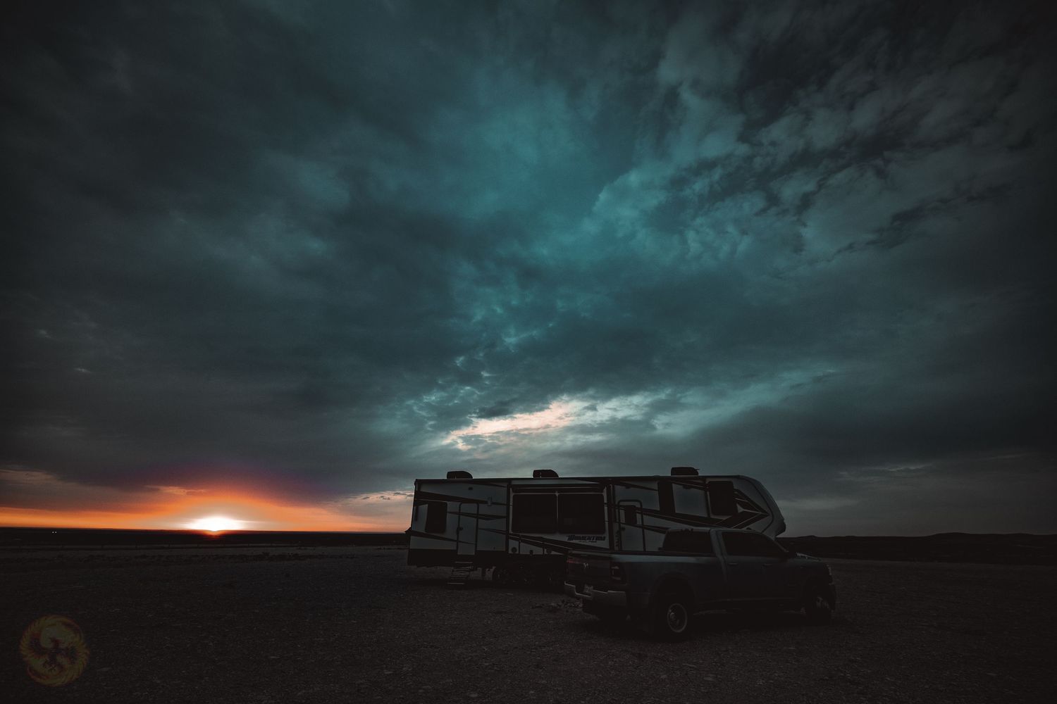 Dramatic stormy sky with turquoise clouds and sunset on the horizon.