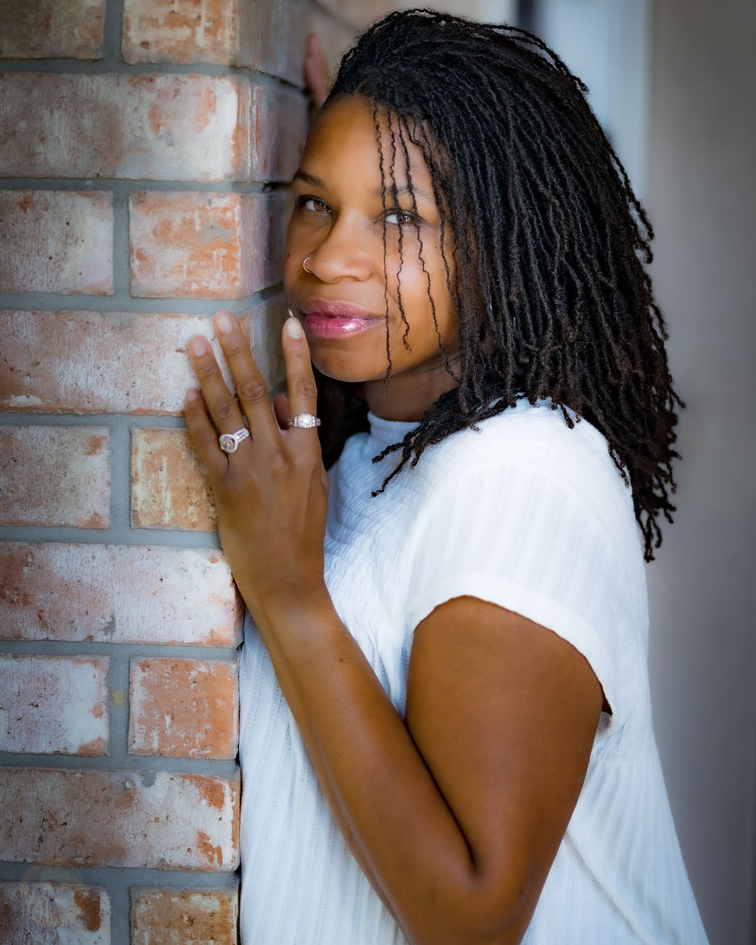 Portrait against brick wall background with artistic lighting.