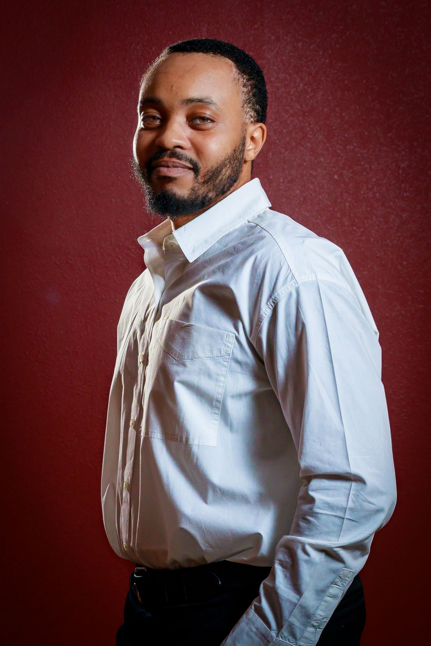 Professional portrait series against red backdrop showing person in white dress shirt posing from different angles.