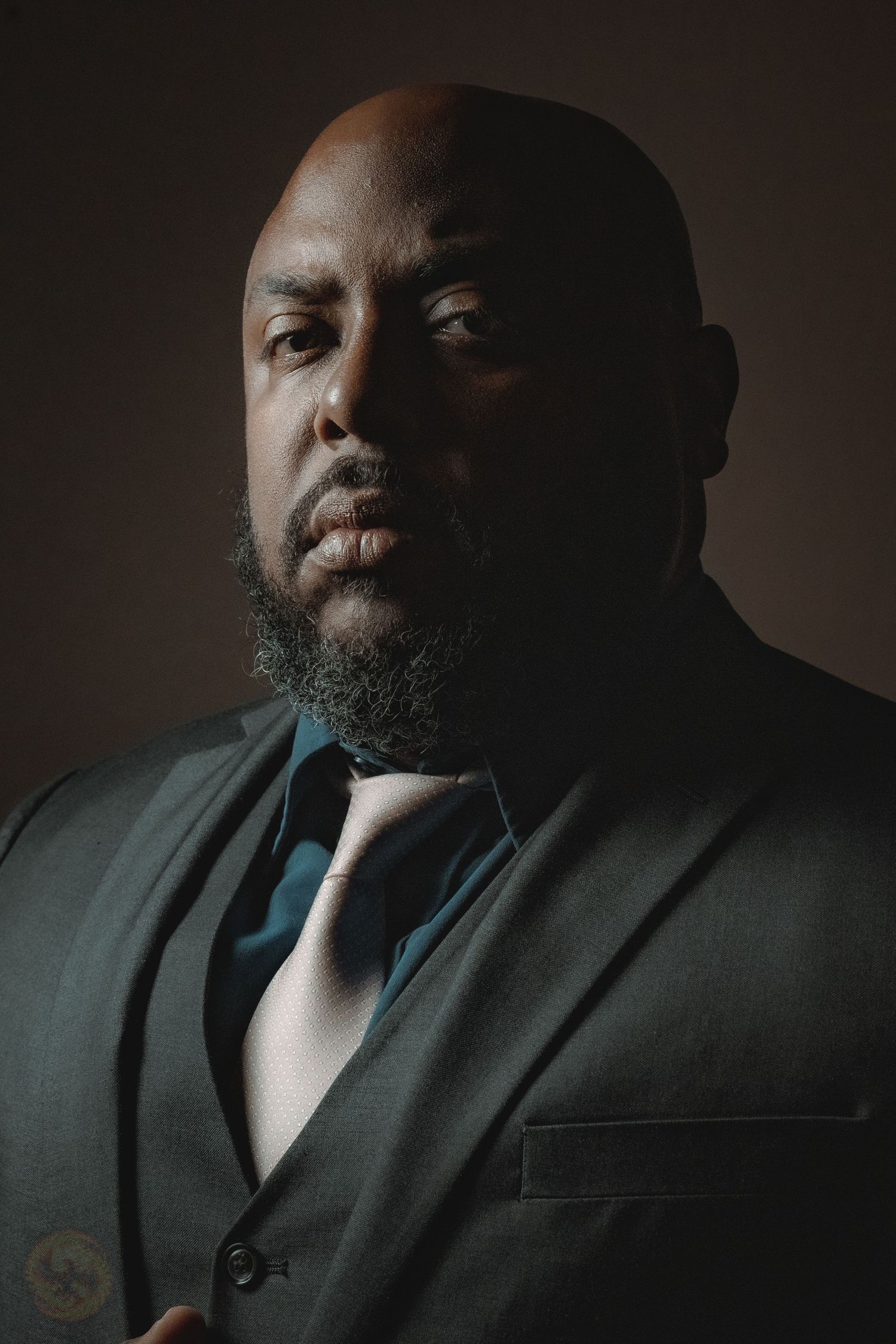 Dramatic low-key portrait with moody lighting and dark background.