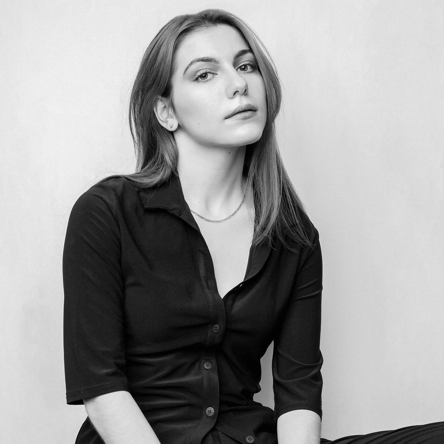 Black and white portrait of a young woman in a black shirt with a thoughtful expression.