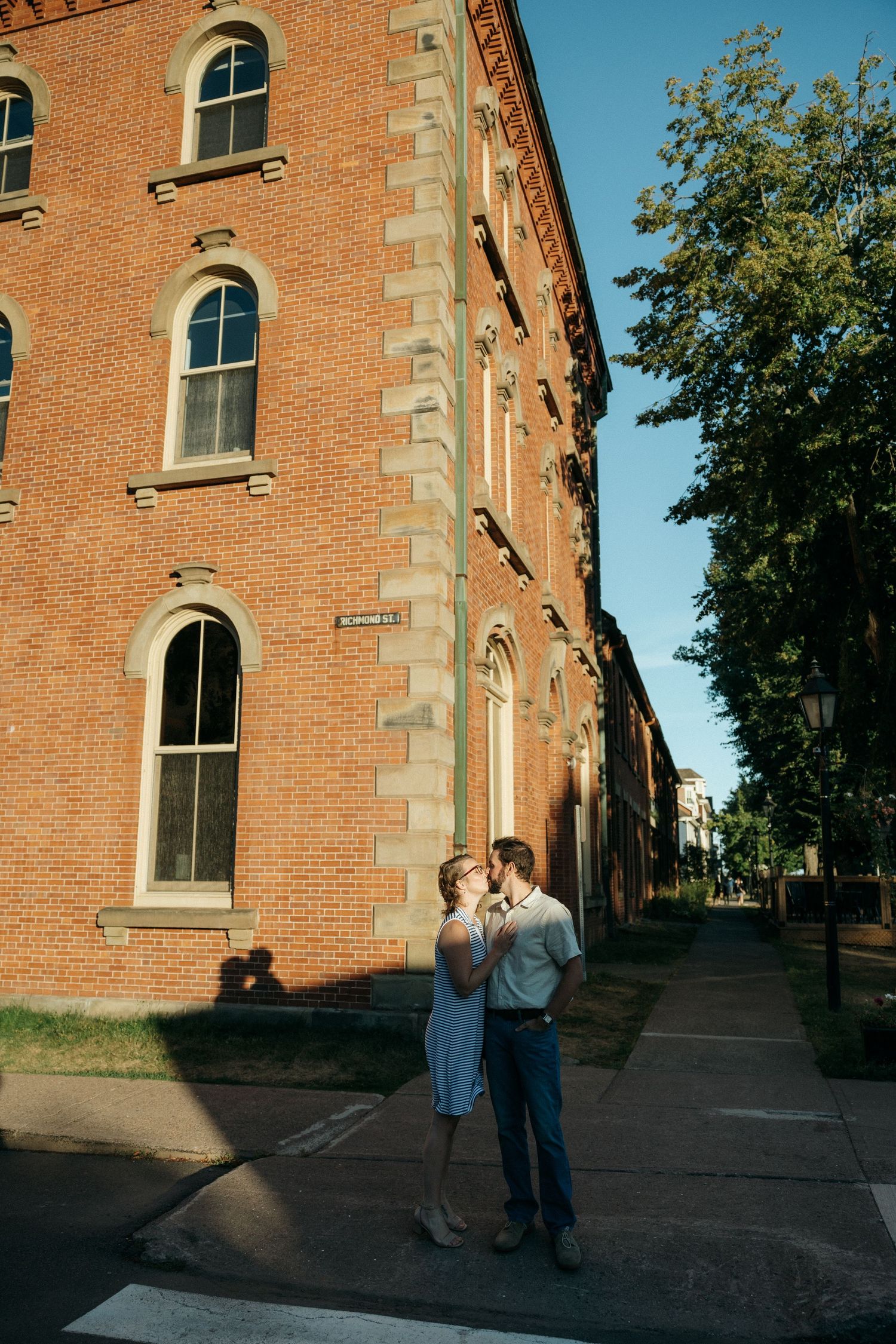 A series of romantic interactions outside a historic brick building with arched windows.