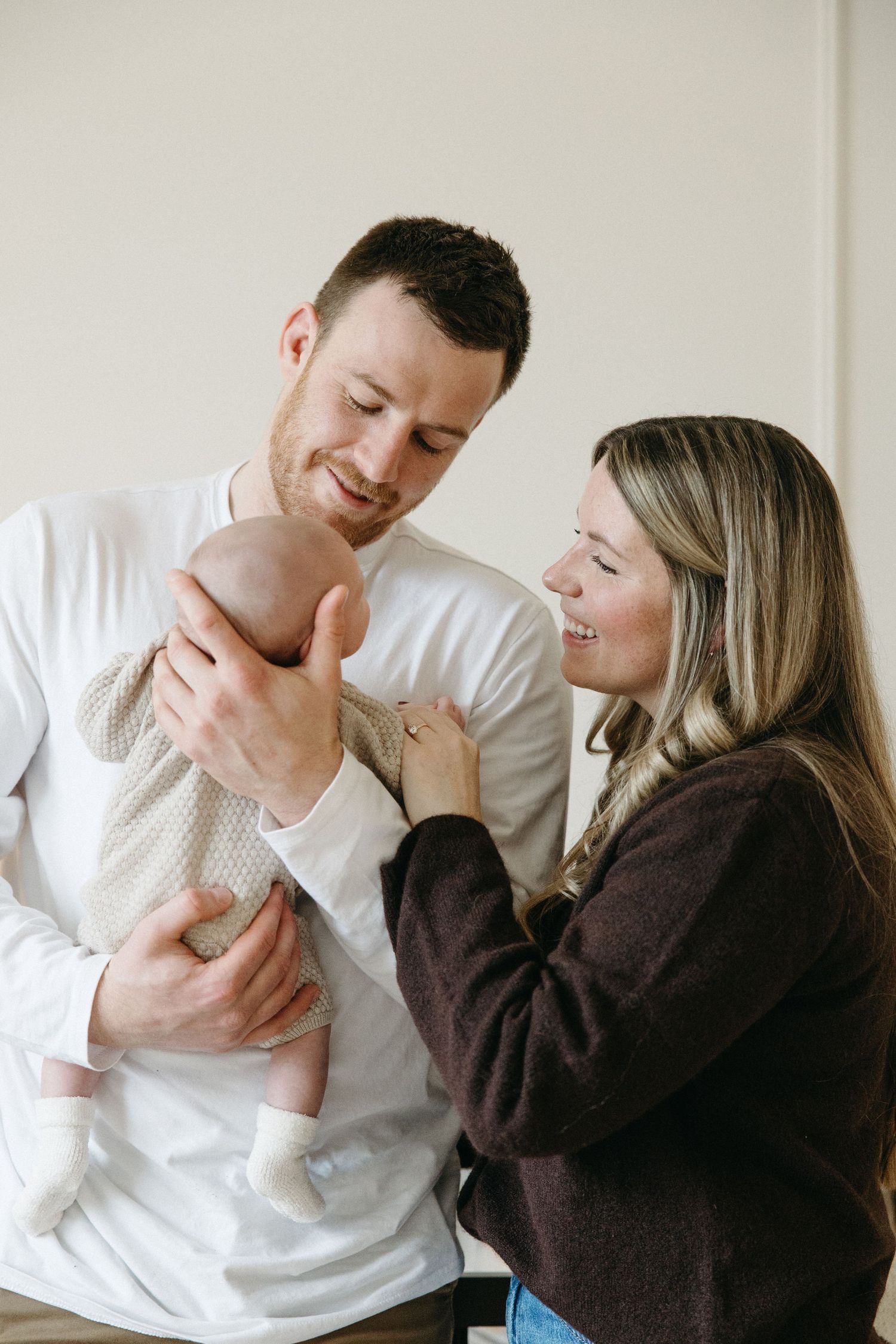 A touching family moment in a bright nursery with modern decor and natural lighting.