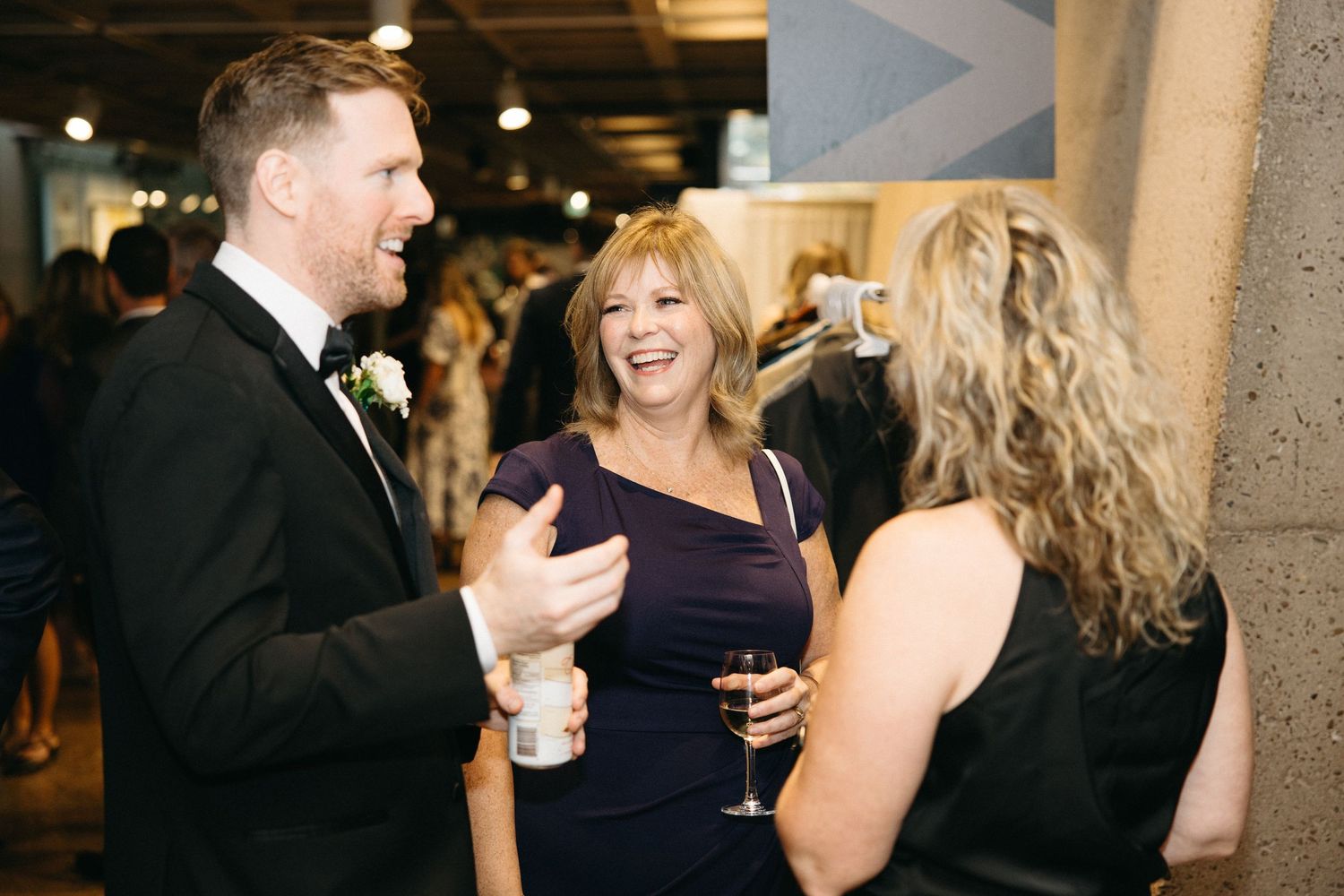 People in formal attire socialize at an elegant evening event.