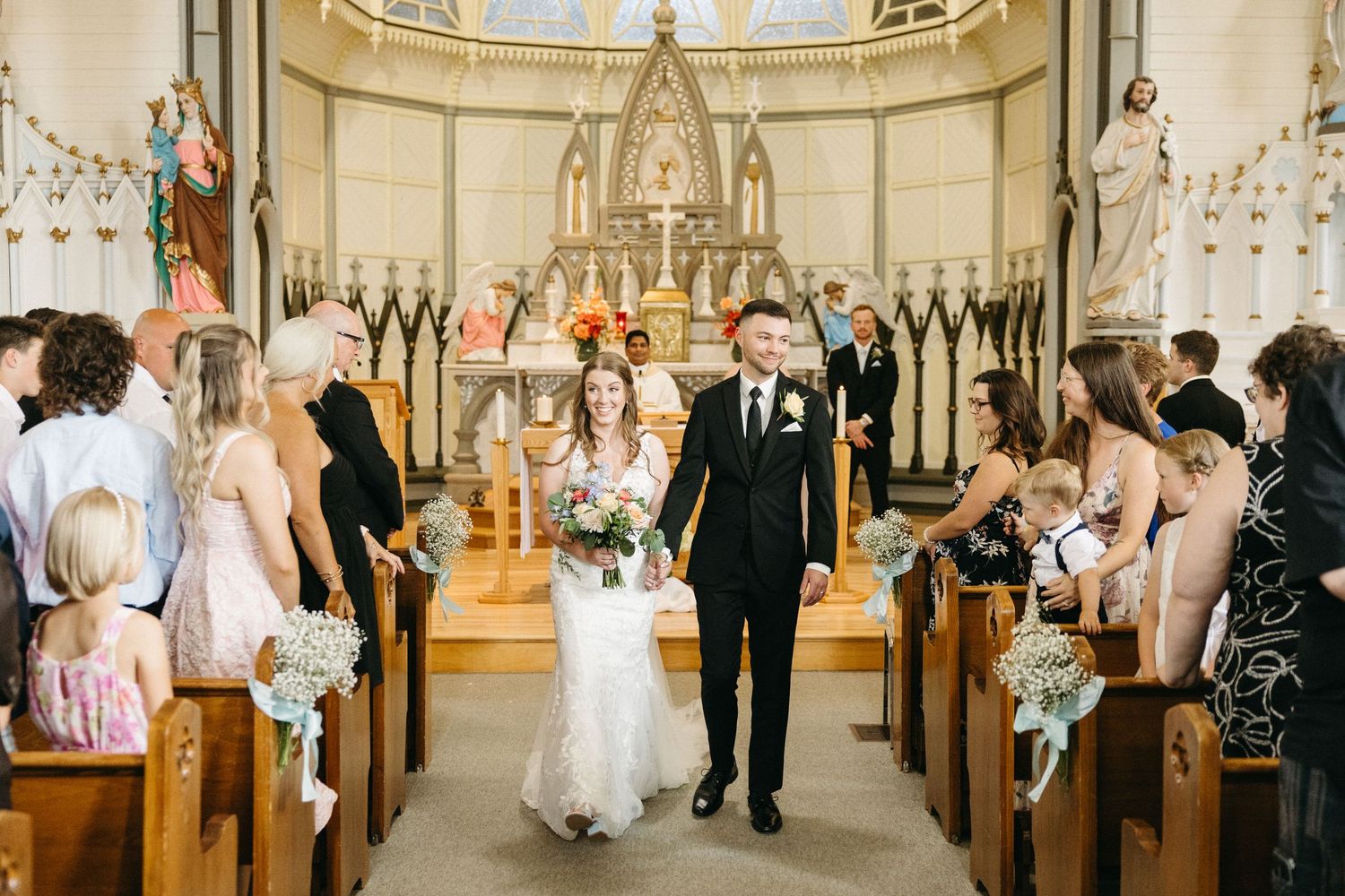 Wide angle view of a church wedding ceremony with Gothic architecture and decorative details.
