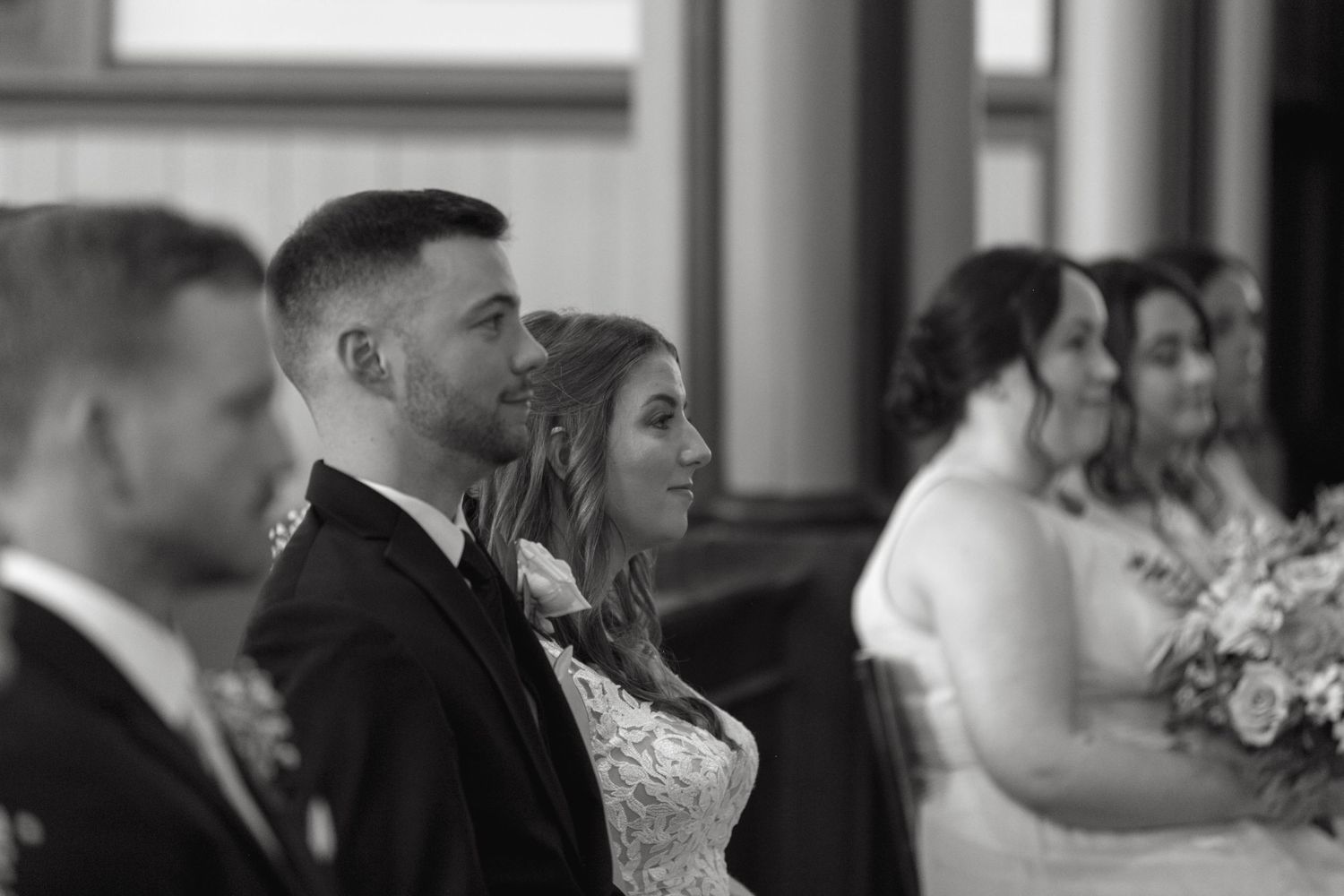 Wedding guests seated in church pews during an indoor ceremony.