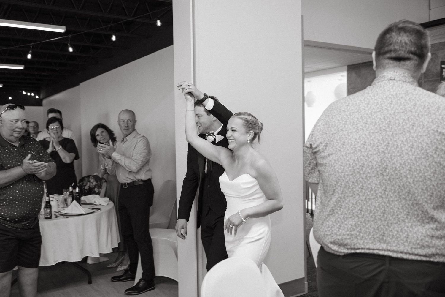 Black and white candid shots of wedding guests interacting at reception.