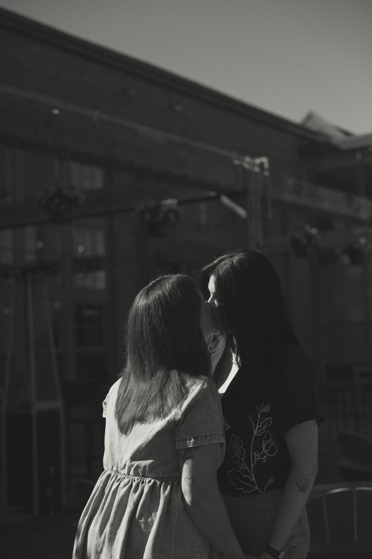 Silhouettes of two people standing close together against a dark background.