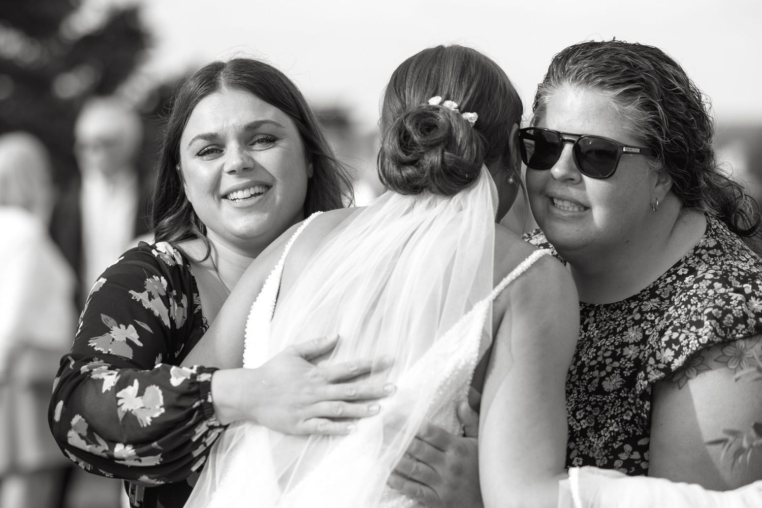 Black and white candid shots of wedding guests sharing emotional moments.