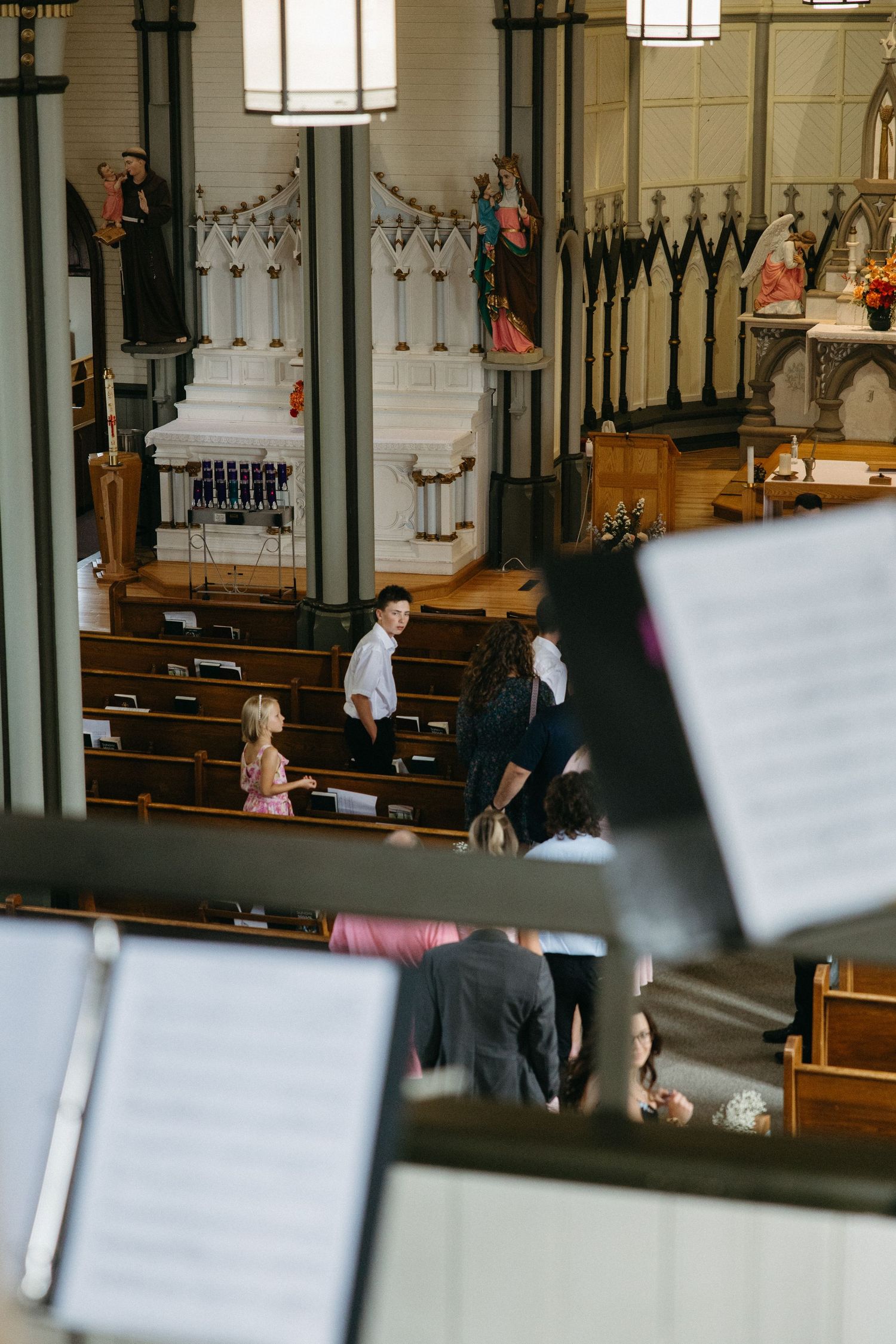 Interior view of a church sanctuary with wooden pews and ornate architectural details.