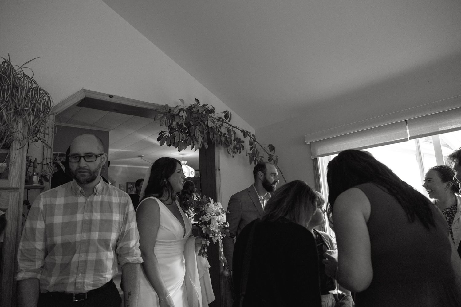 Wedding reception guests gather indoors for celebrations and conversations.