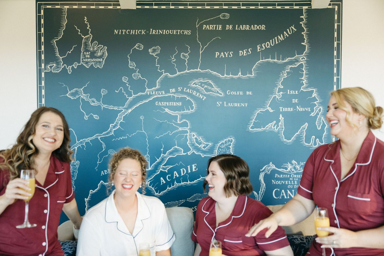 Group enjoying drinks and conversation against blue wall with map artwork.