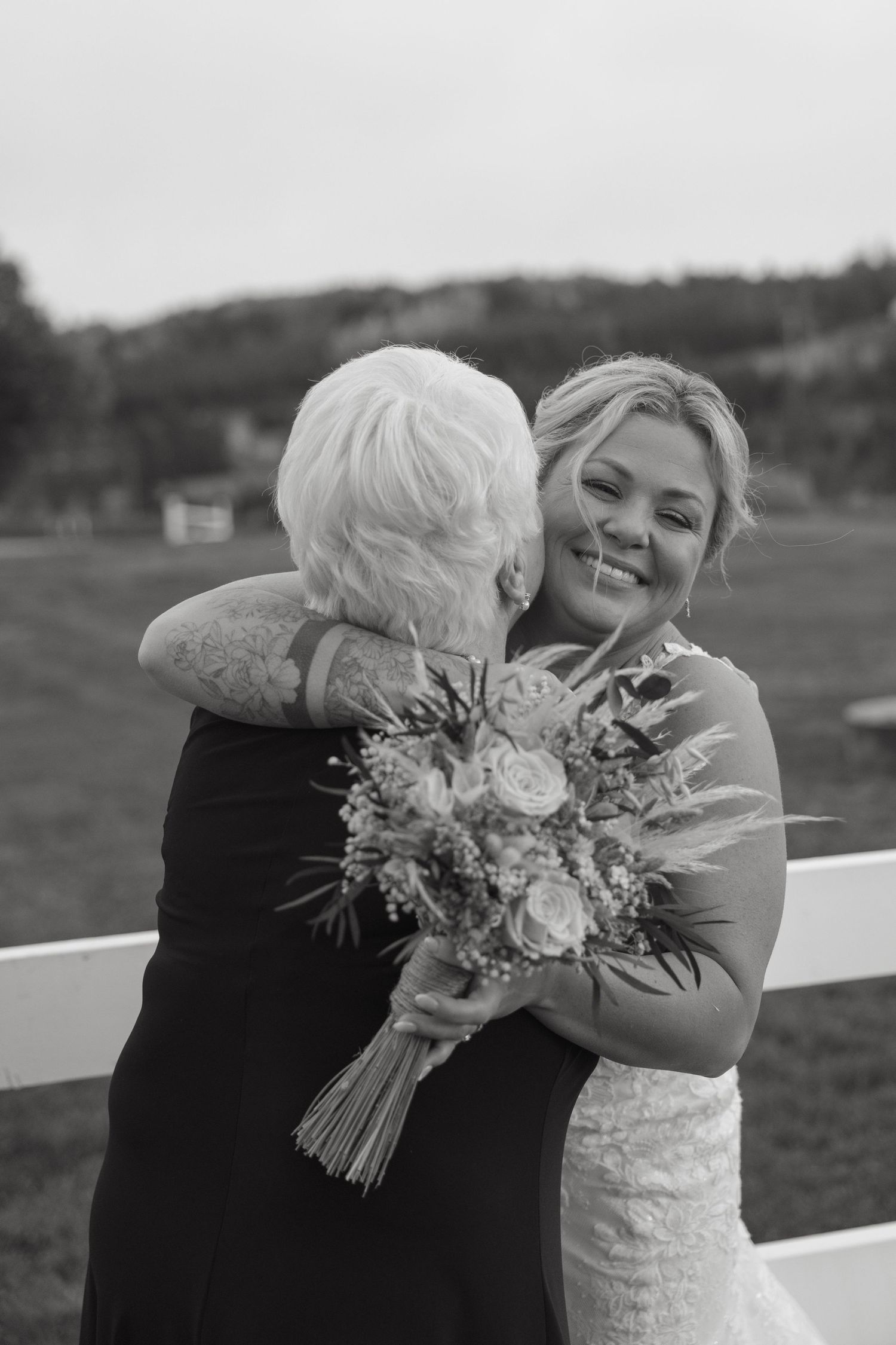 Emotional wedding moment captured in black and white with floral bouquet.