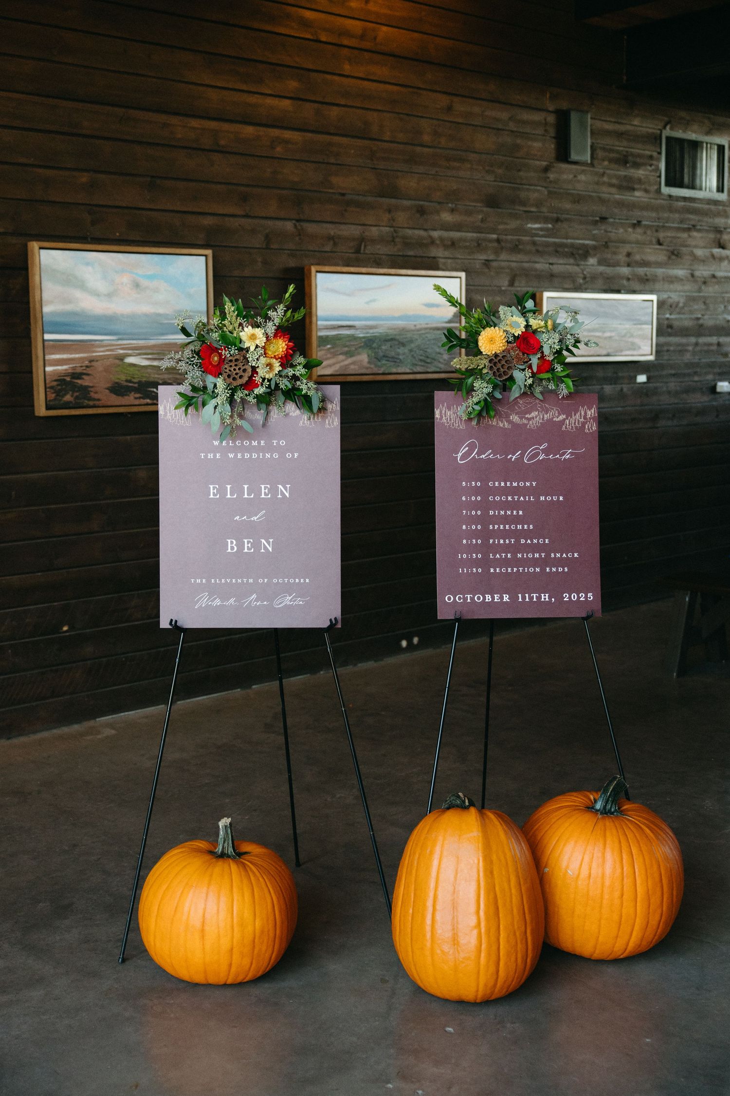 Wedding signage displayed on easels with orange pumpkins as seasonal decor.