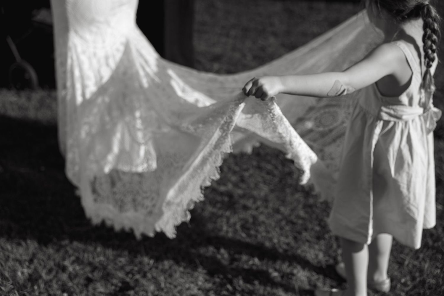 Close-up details of flowing white wedding dress fabric in black and white.