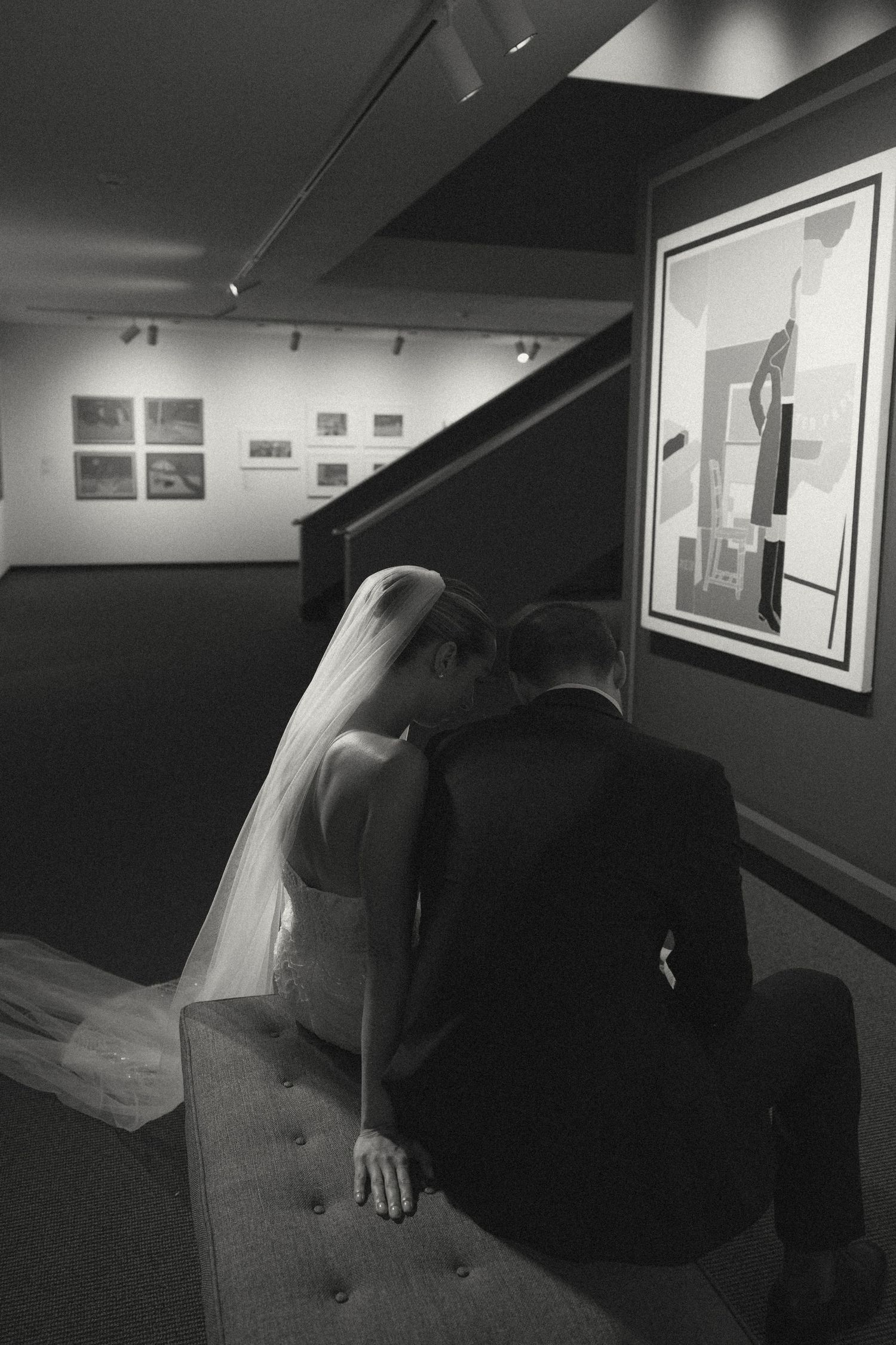 Black and white artistic wedding photos displayed in a gallery setting.