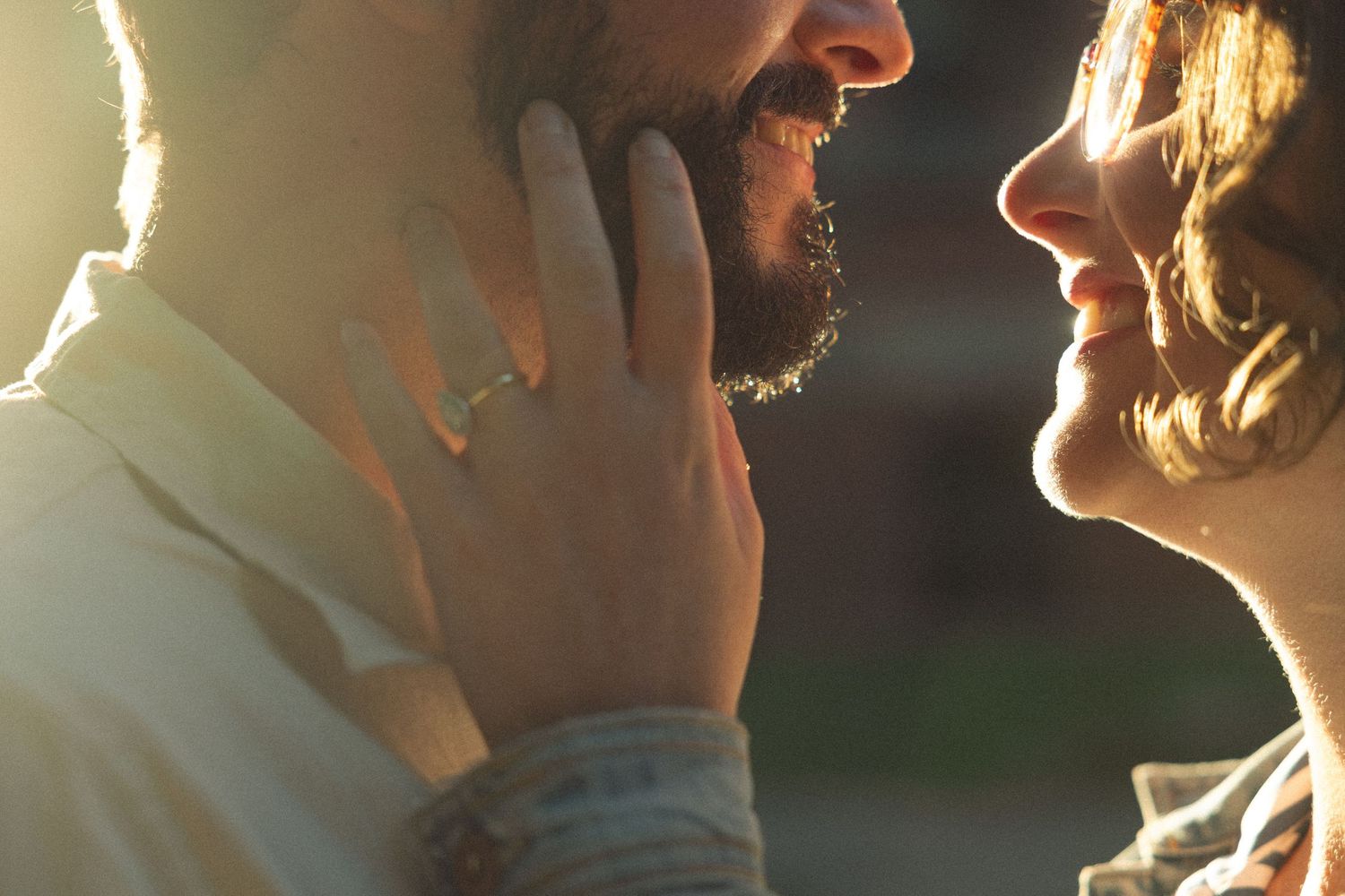 Close-up silhouette profile shot of two people in warm sunlight.