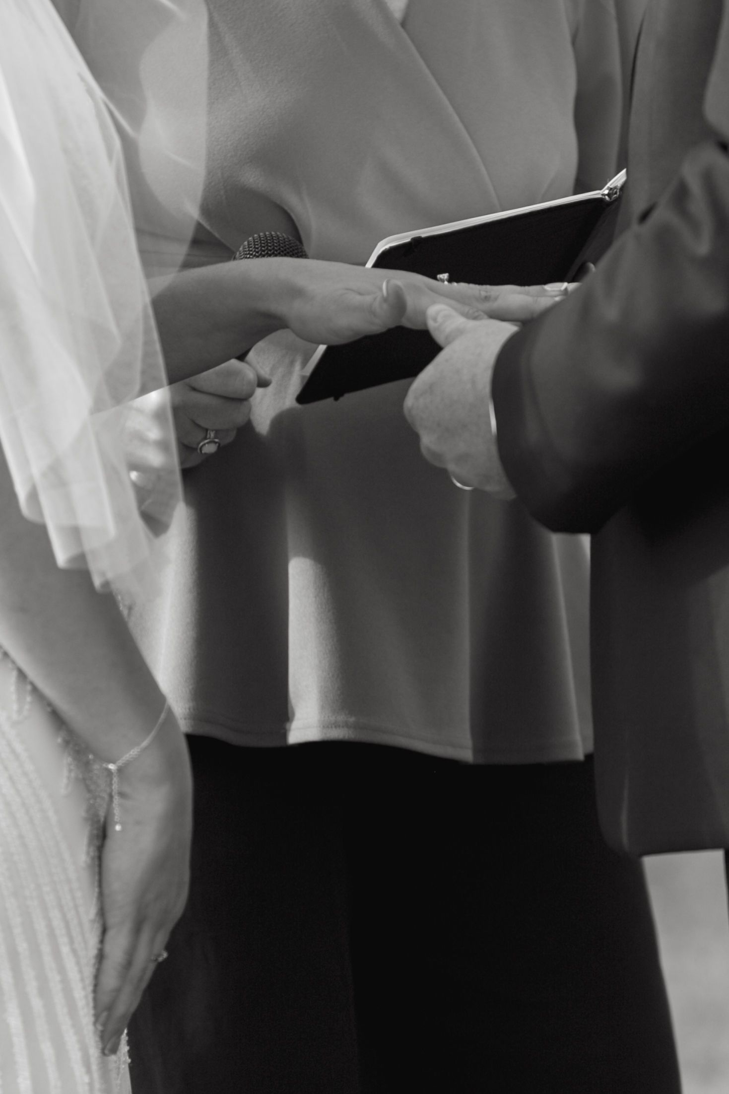 Wedding ceremony attendees stand together in formal attire during an indoor event.