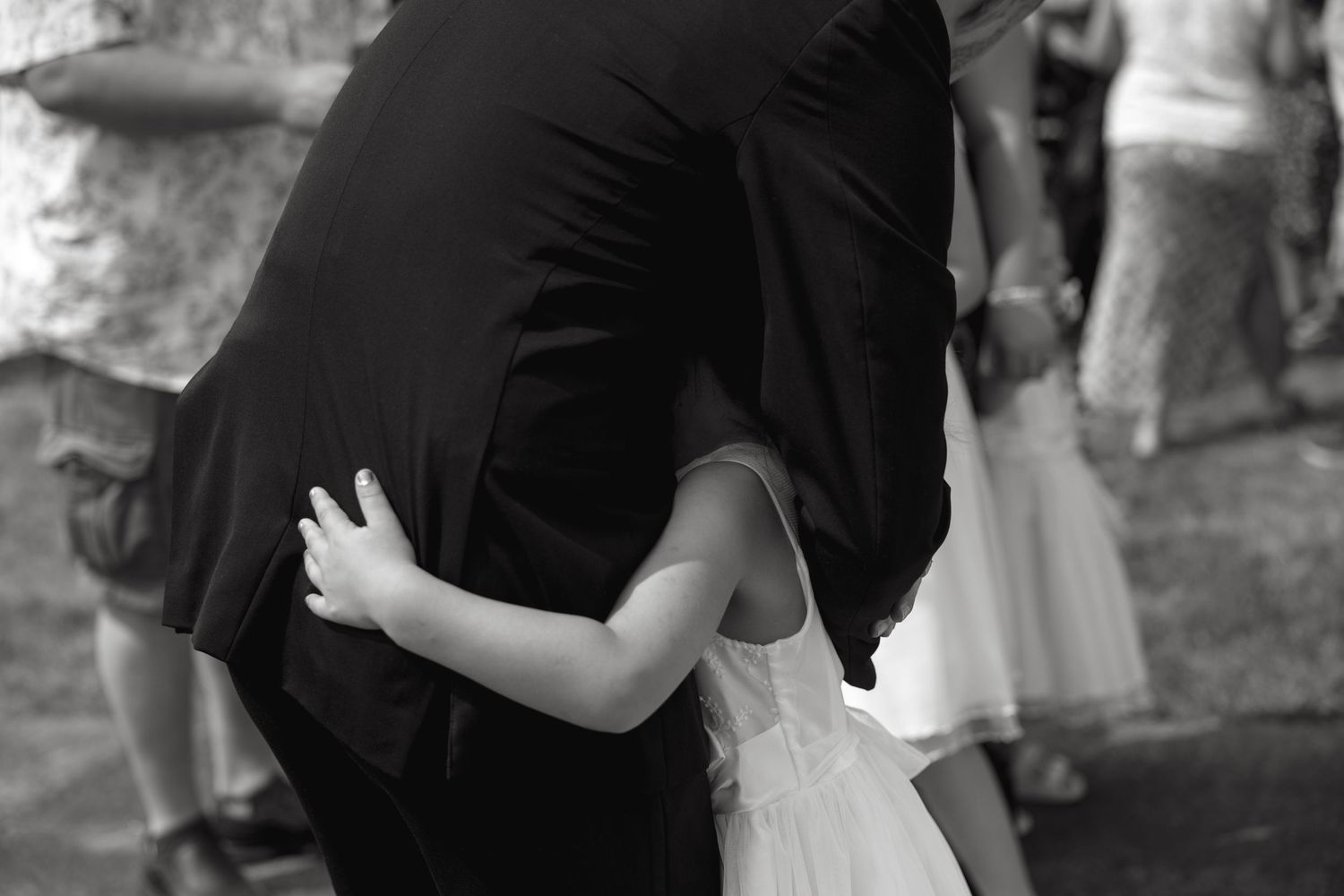 Black and white photo of wedding couple embracing during first look moment.