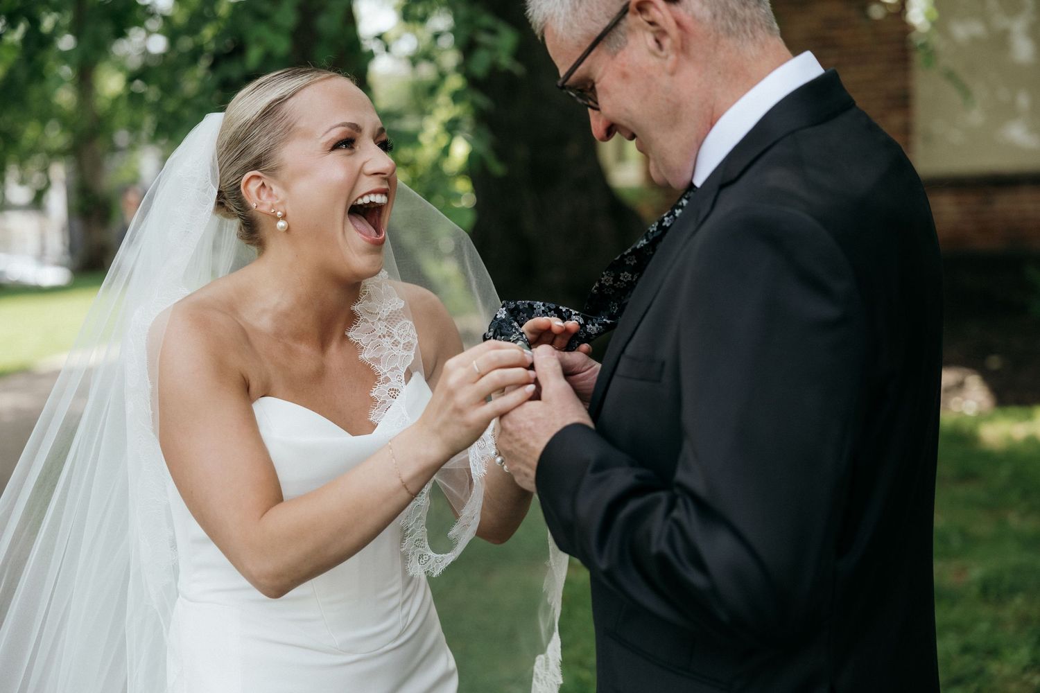 A joyful moment between newlyweds exchanging rings during an outdoor wedding ceremony.