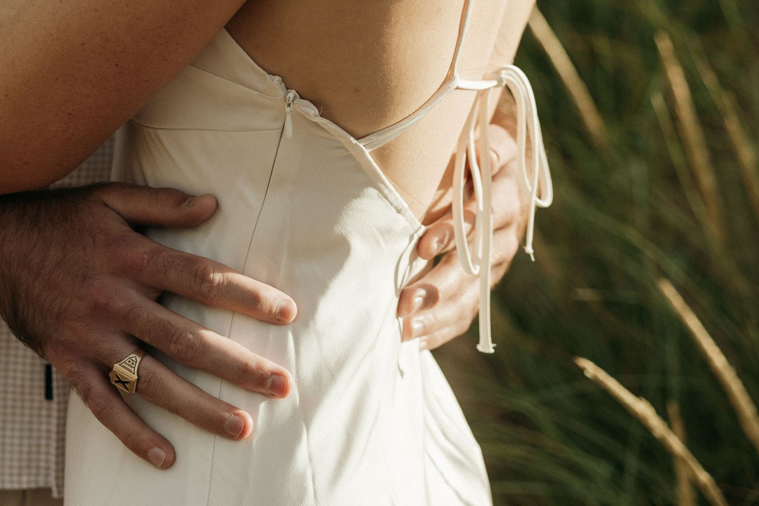 Close-up detail shots of a couple's embrace showing hands and clothing.