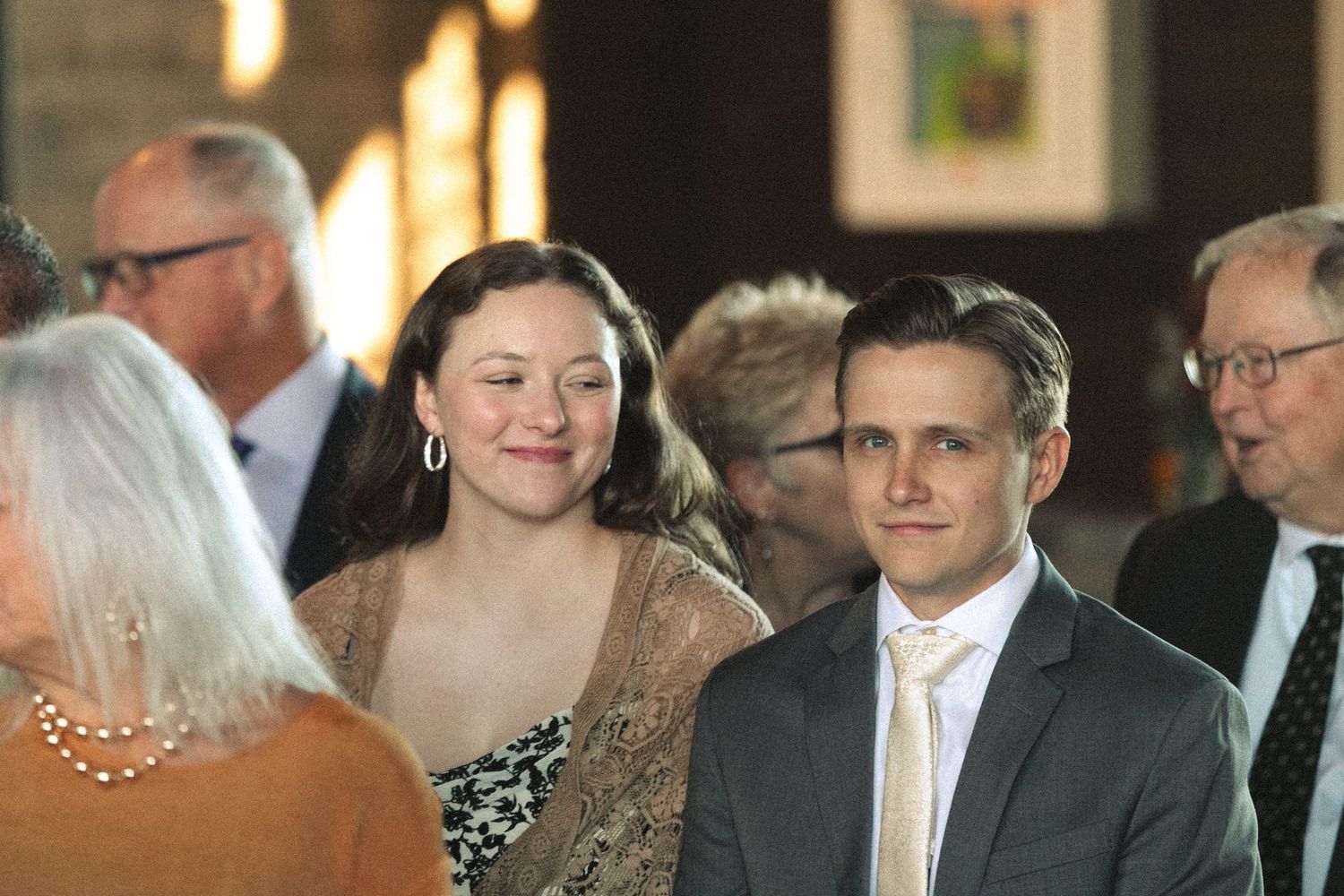 Guests gathered at an indoor evening celebration with warm lighting.