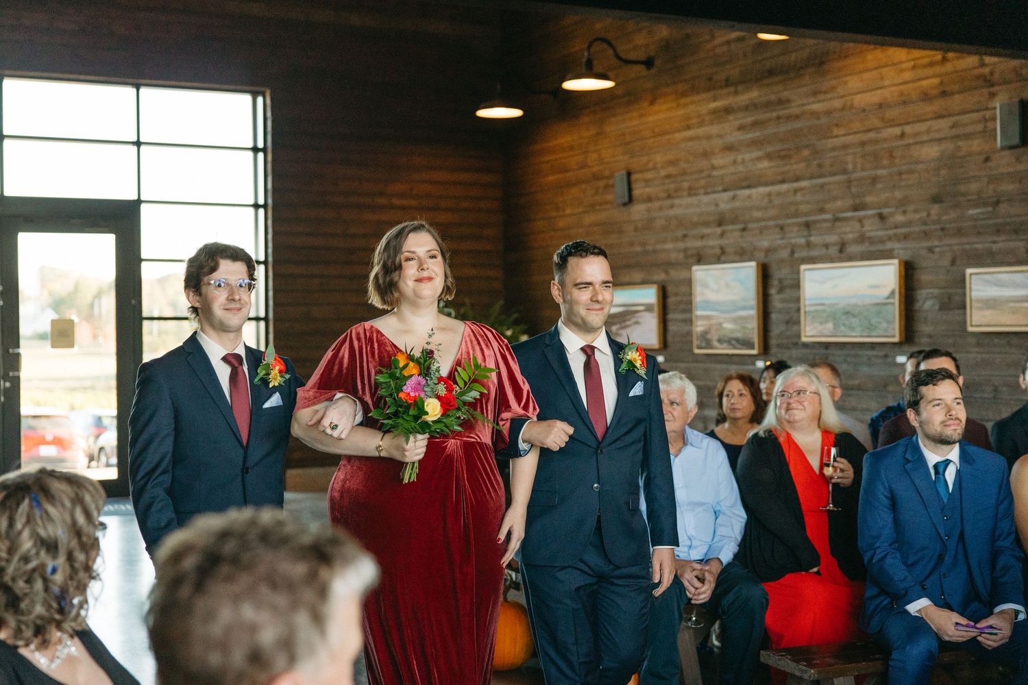 Wedding celebration gathering in industrial-style venue with exposed brick walls and large windows.