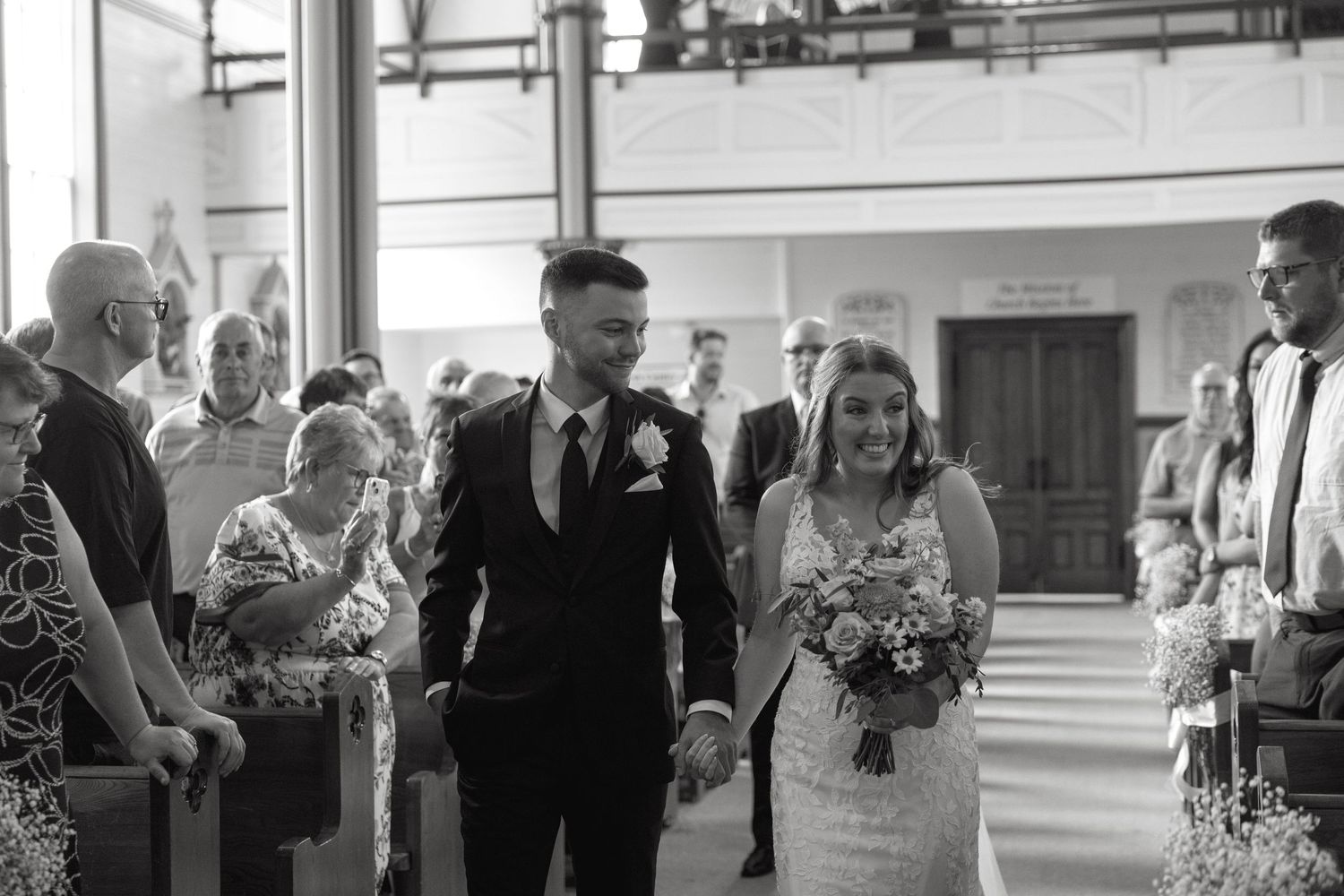 Wedding guests mingling inside a bright church sanctuary.