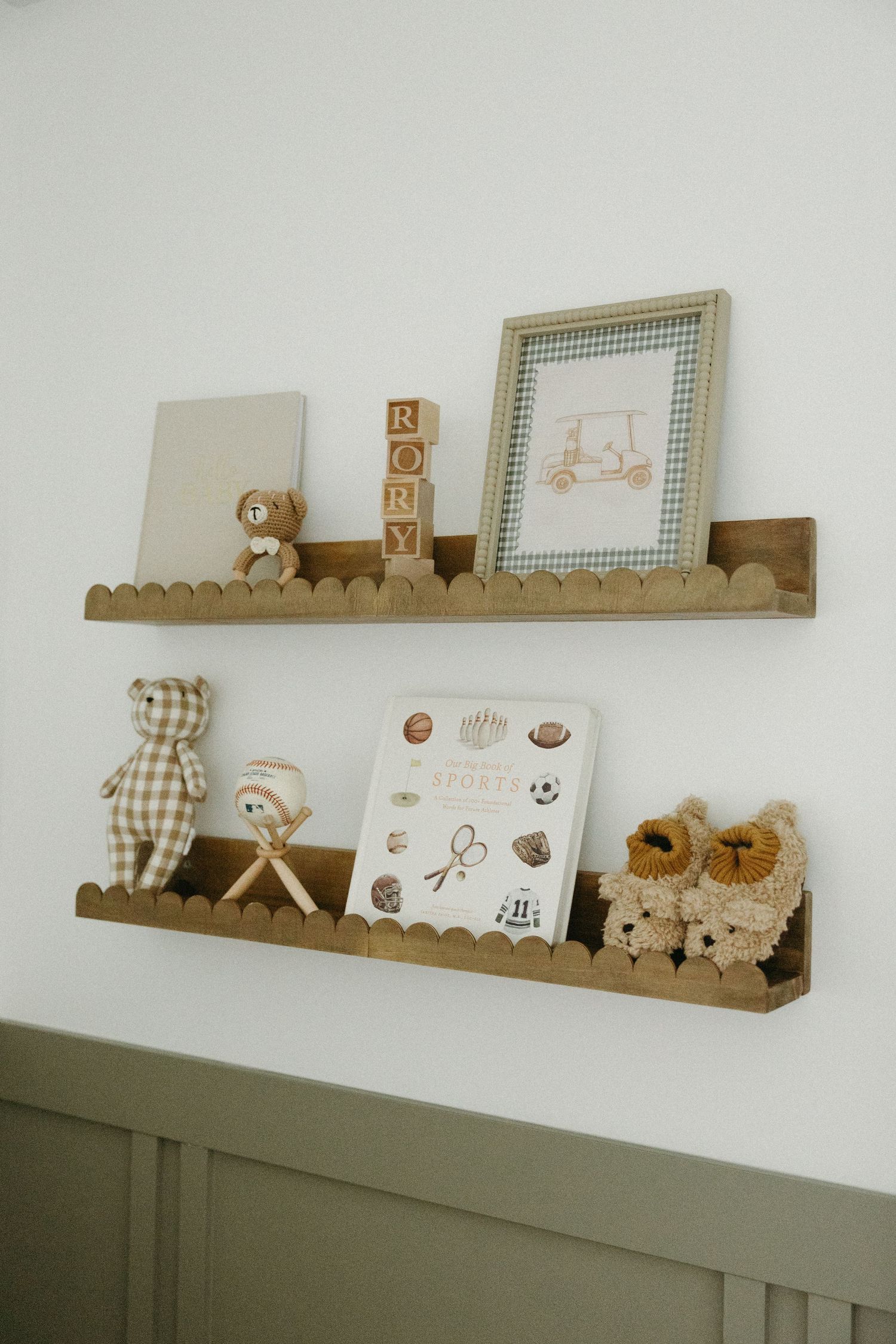 Decorative wooden shelves displaying nursery decor items and teddy bears against a white wall.