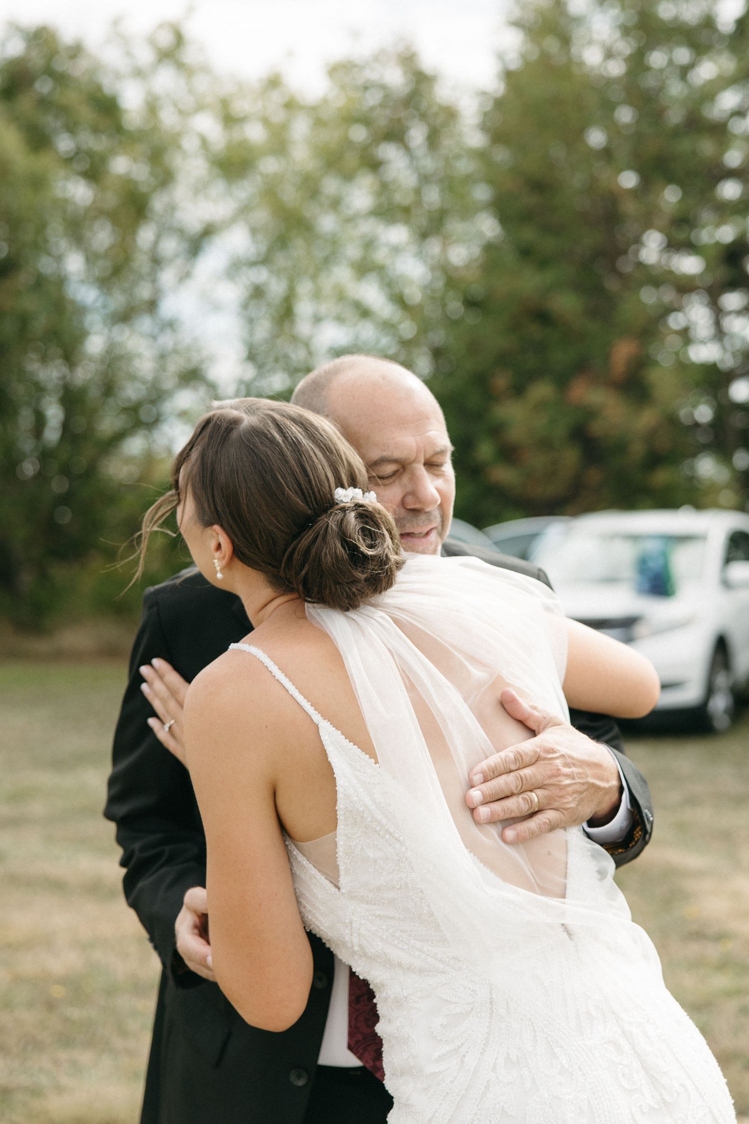Emotional outdoor wedding moment captured in a series of candid embraces.