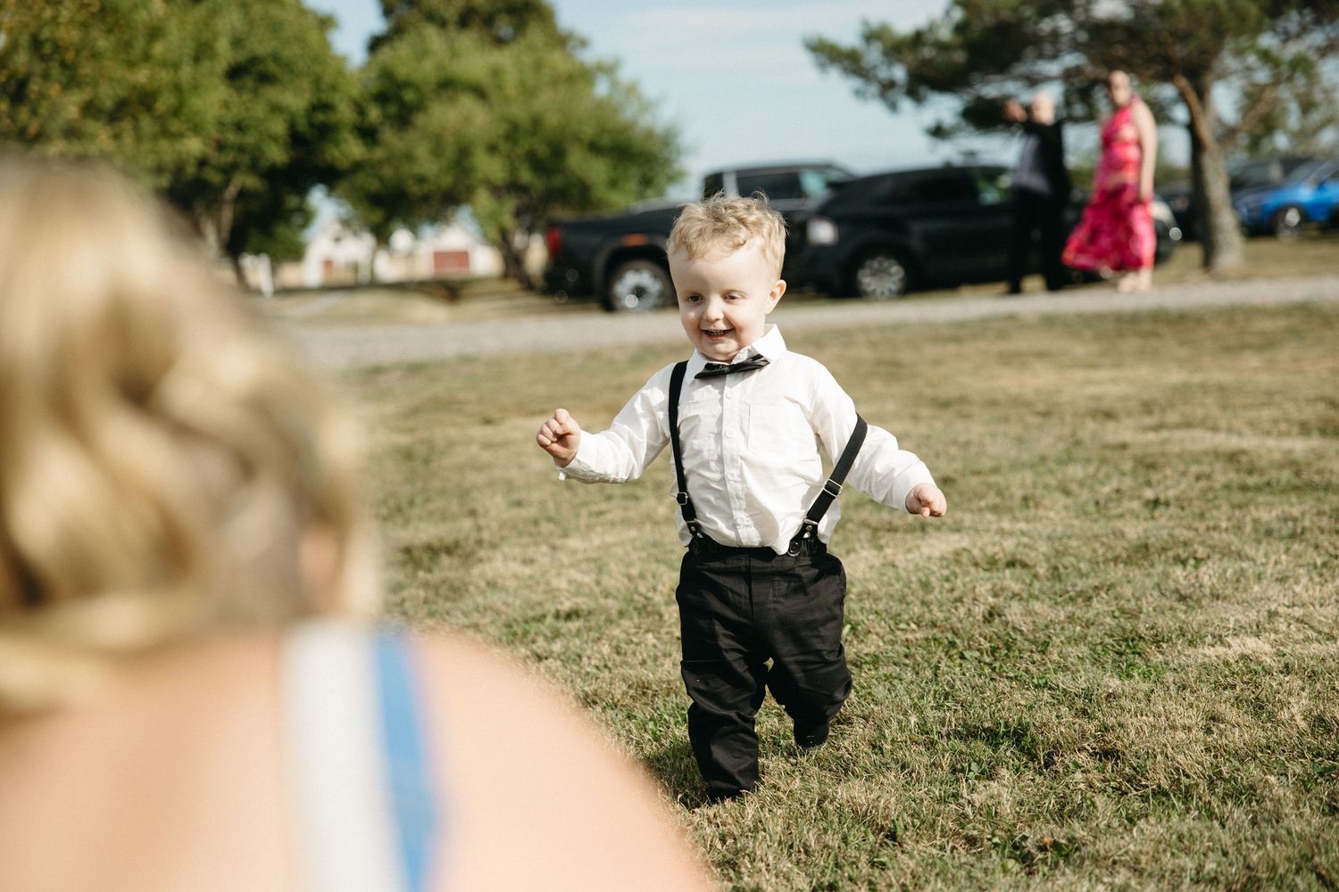 Small children running and playing on grass during an outdoor event.