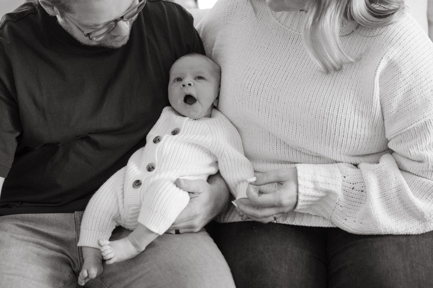 Family shares candid moments with their newborn baby in a series of intimate poses.